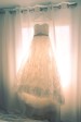 Vestido de novia colgado de unas cortinas.