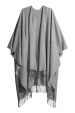 Poncho de color gris con flecos de H&M (34,99 euros).