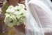 Aparece en primer plano el ramo de la novia y los detalles de la manga del vestido. Es un ramo muy coqueto formado por rosas de pitiminí.