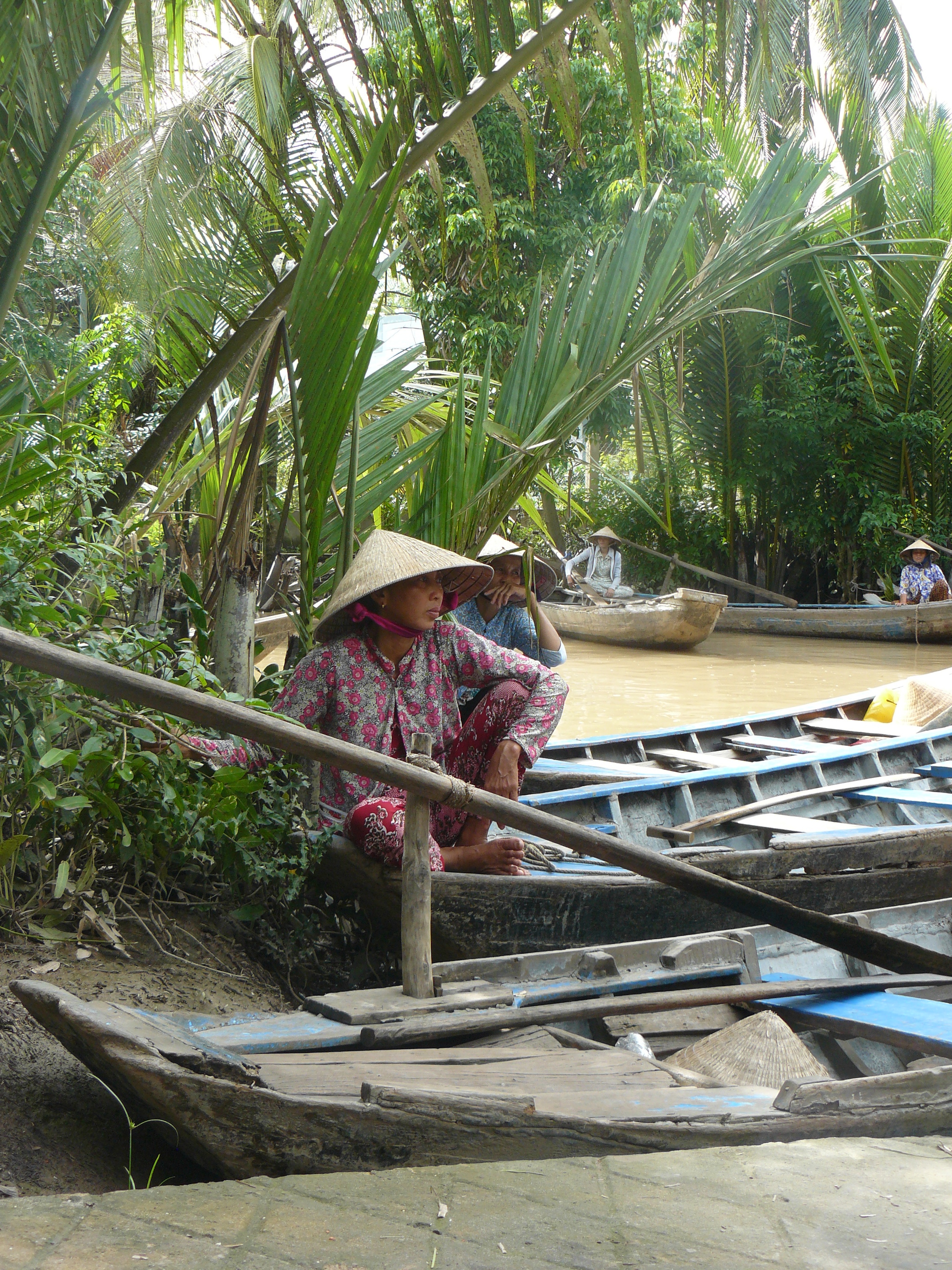 Habilidosos vietnamitas dirigen sus barcas de junco por los canales...