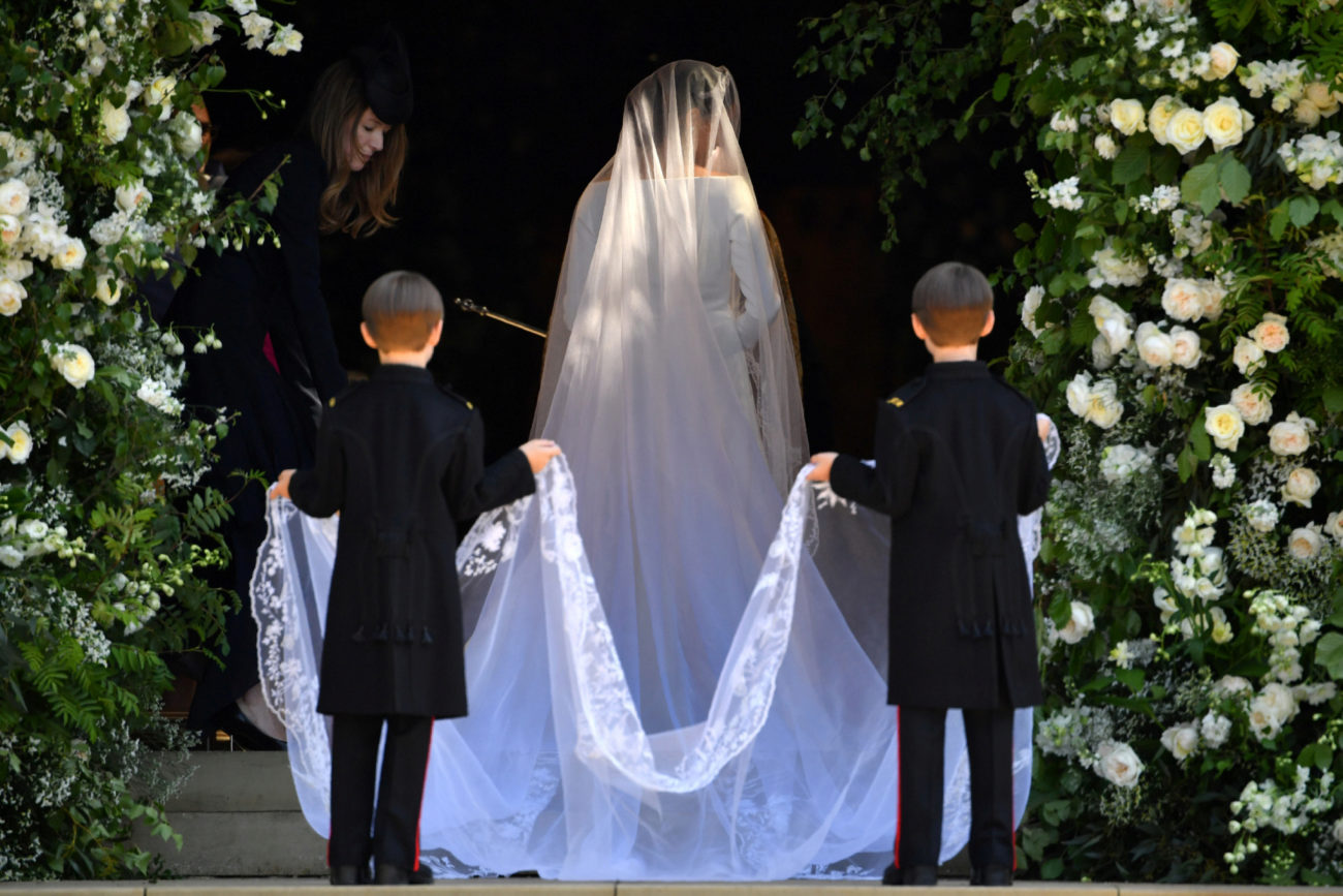 Los dos pajes sujetan el velo de la novia a su entrada en la capilla.