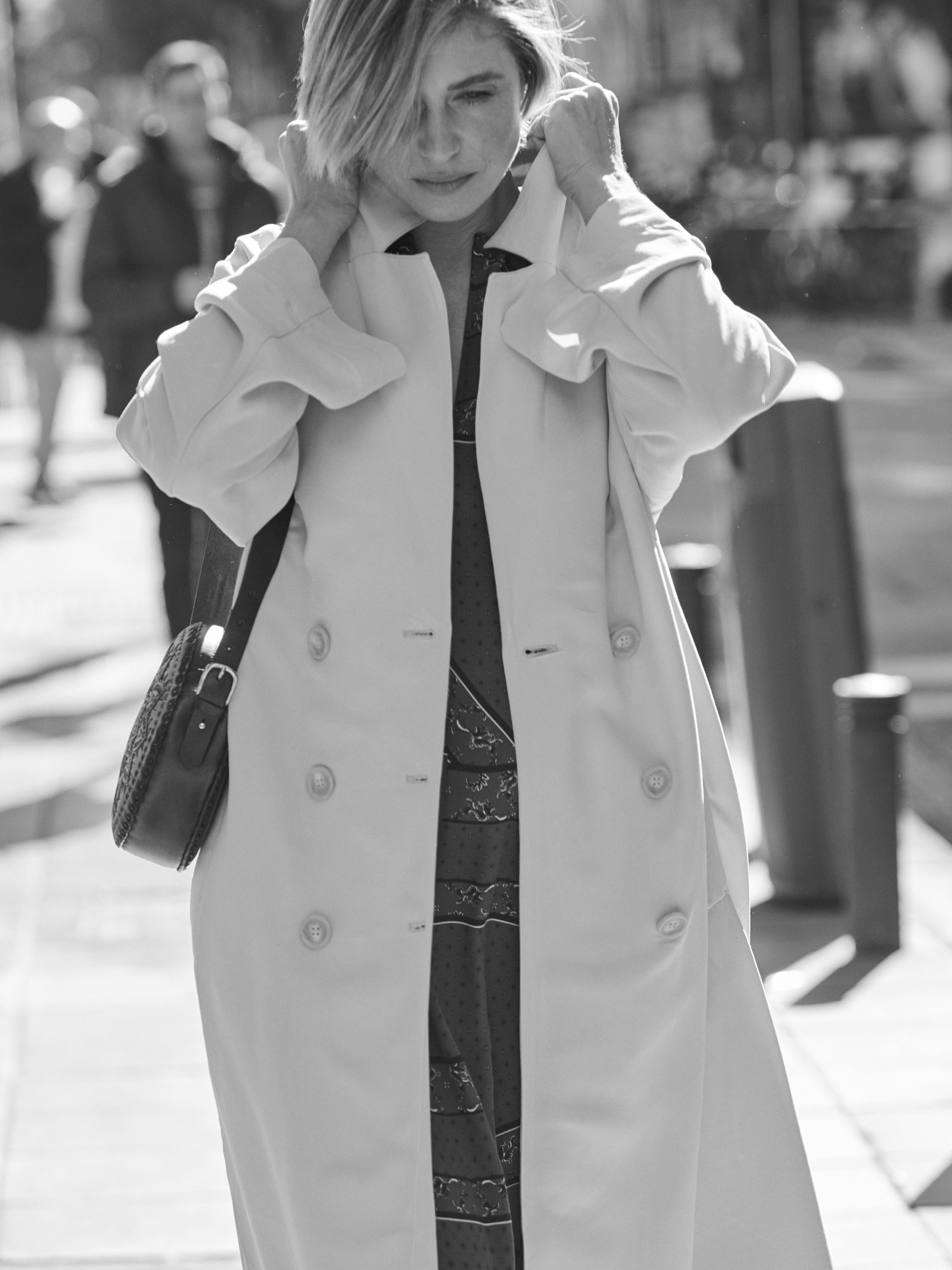 Martina Klein posa con vestido de GANNI en MYTHERESA; trench de H&M y bolso de piel de ANTIK BATIK.