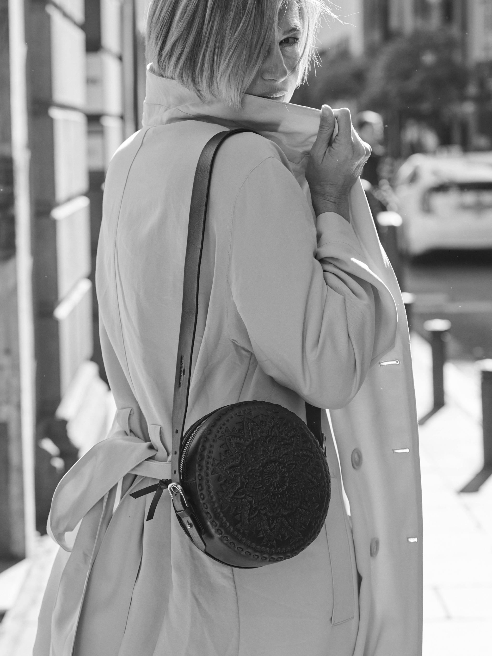 Martina Klein posa con vestido de GANNI en MYTHERESA; trench de H&M y bolso de piel de ANTIK BATIK.