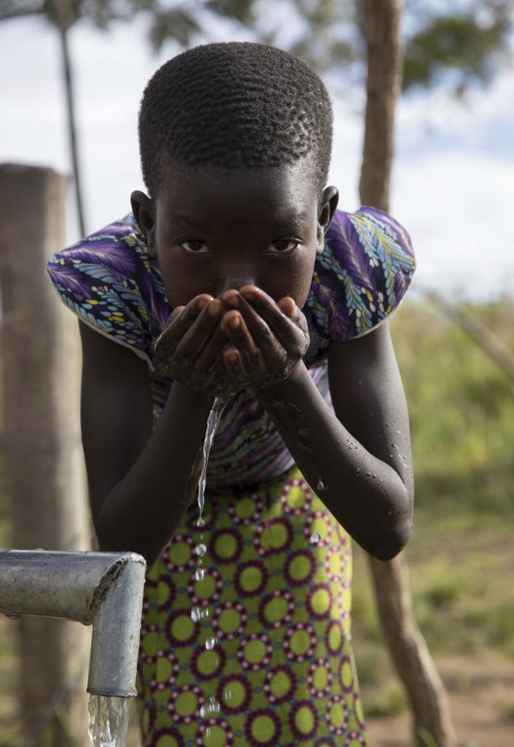 Un nio de Oluko bebiendo agua.