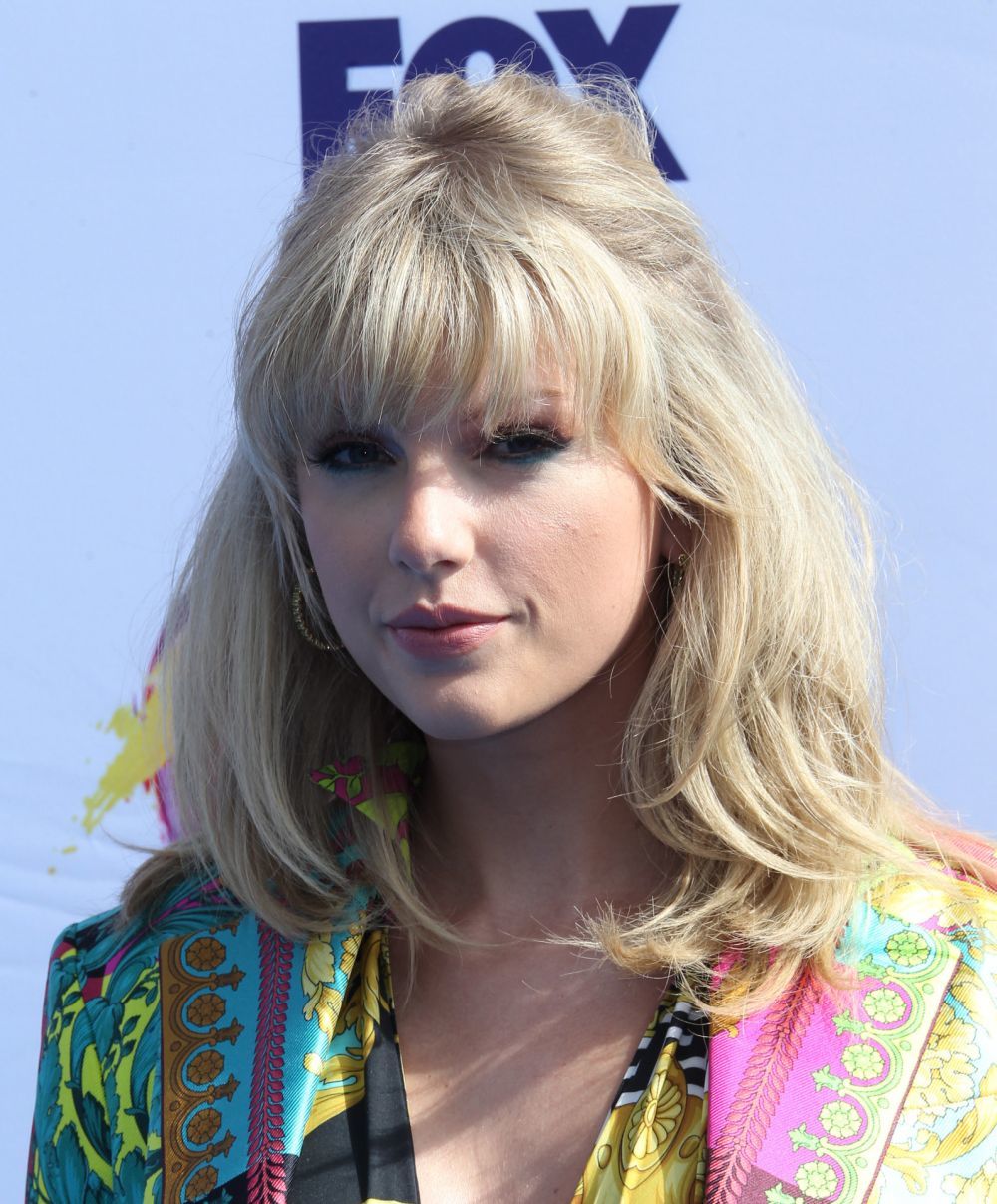 Taylor Swift luce semirrecogidos con flequillo y con volumen en la coronilla al más puro estilo retro.