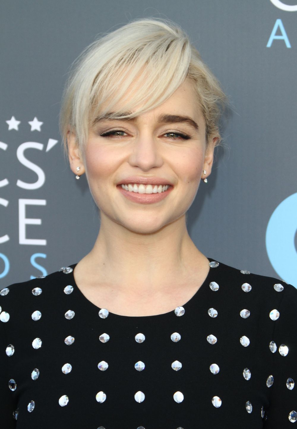 Emilia Clarke se ha decantado por un flequillo lateral para su corte de pelo pixie platino que funciona genial sobre su rostro redondo.