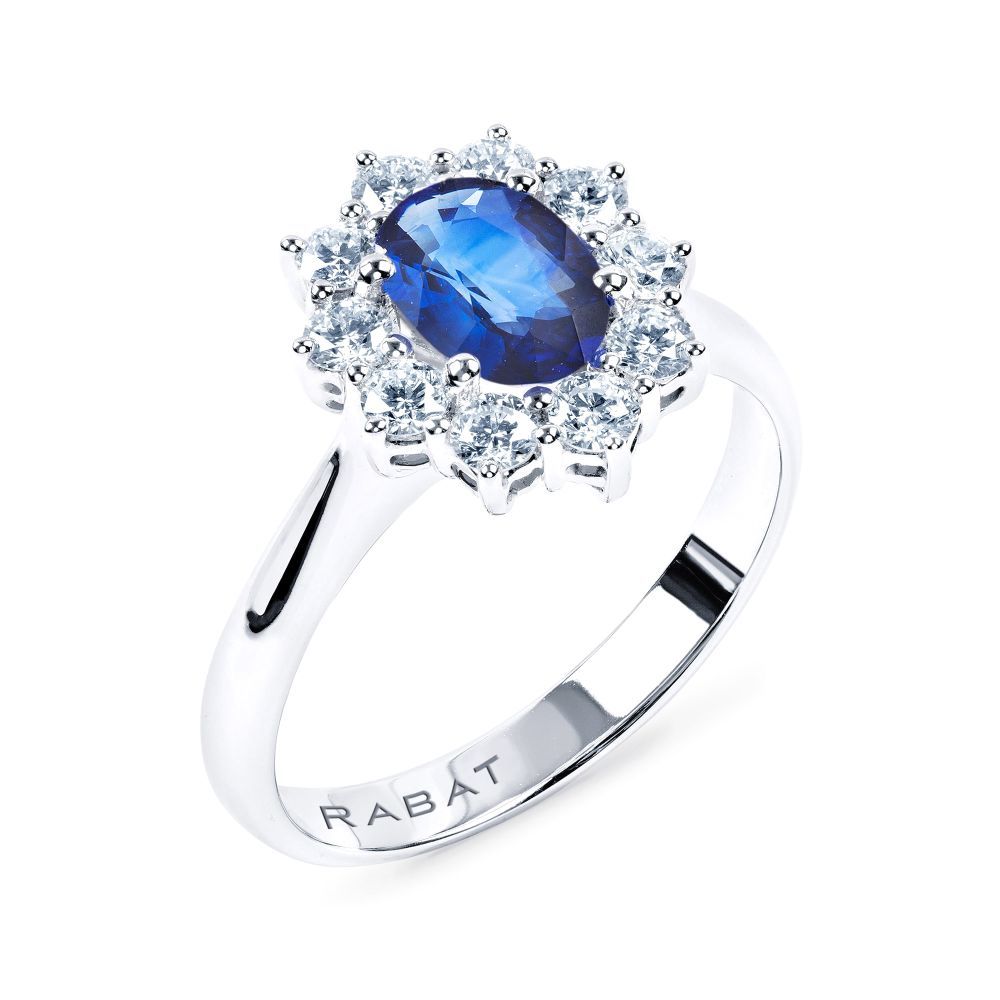 Anillo de oro blanco con zafiro azul central talla oval y orla de diamantes talla brillante.De RABAT.
