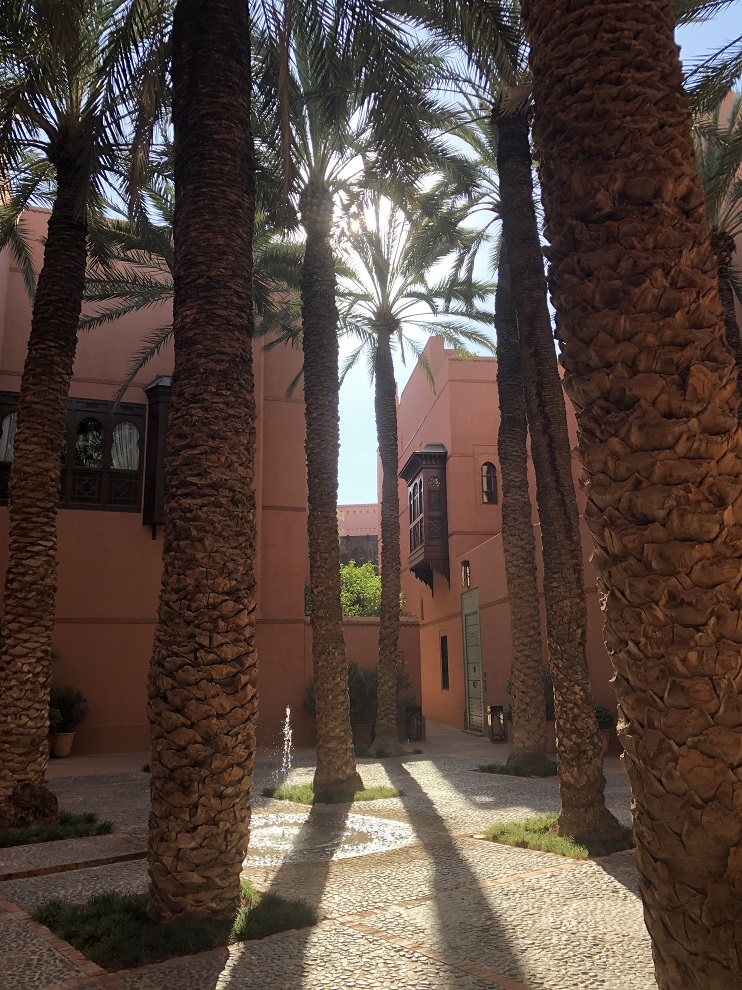 Una de las "plazas" del hotel con palmeras centenarias, alrededor de la que se reparten dos riads. Los planos del hotel se cambiaron para respetar la vegetación autóctona.