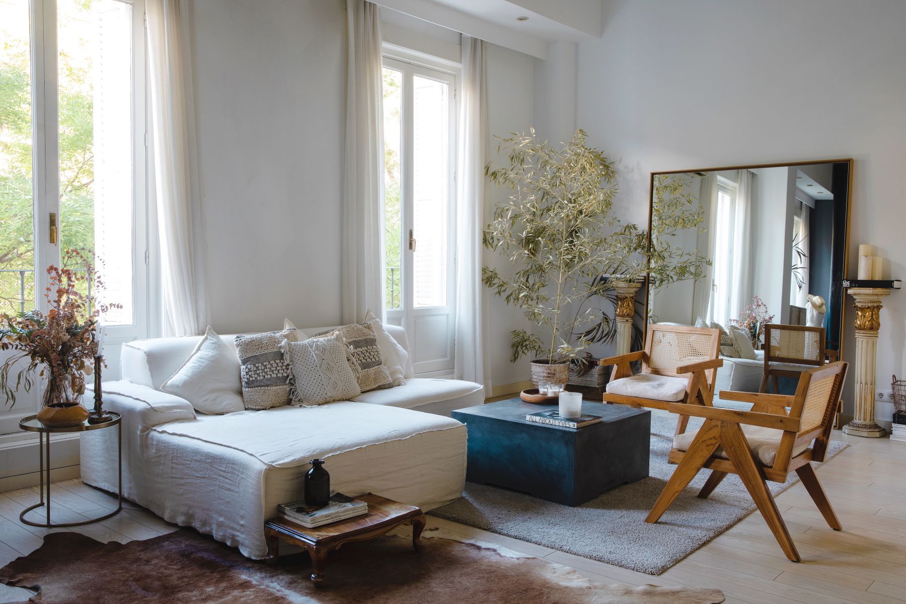 En el salón de la casa de Claudia Llagostera, sofá, diseñado por  Patricia Pombo con cojines de crochet, de Primark y un gran espejo hecho a medida por Decolab