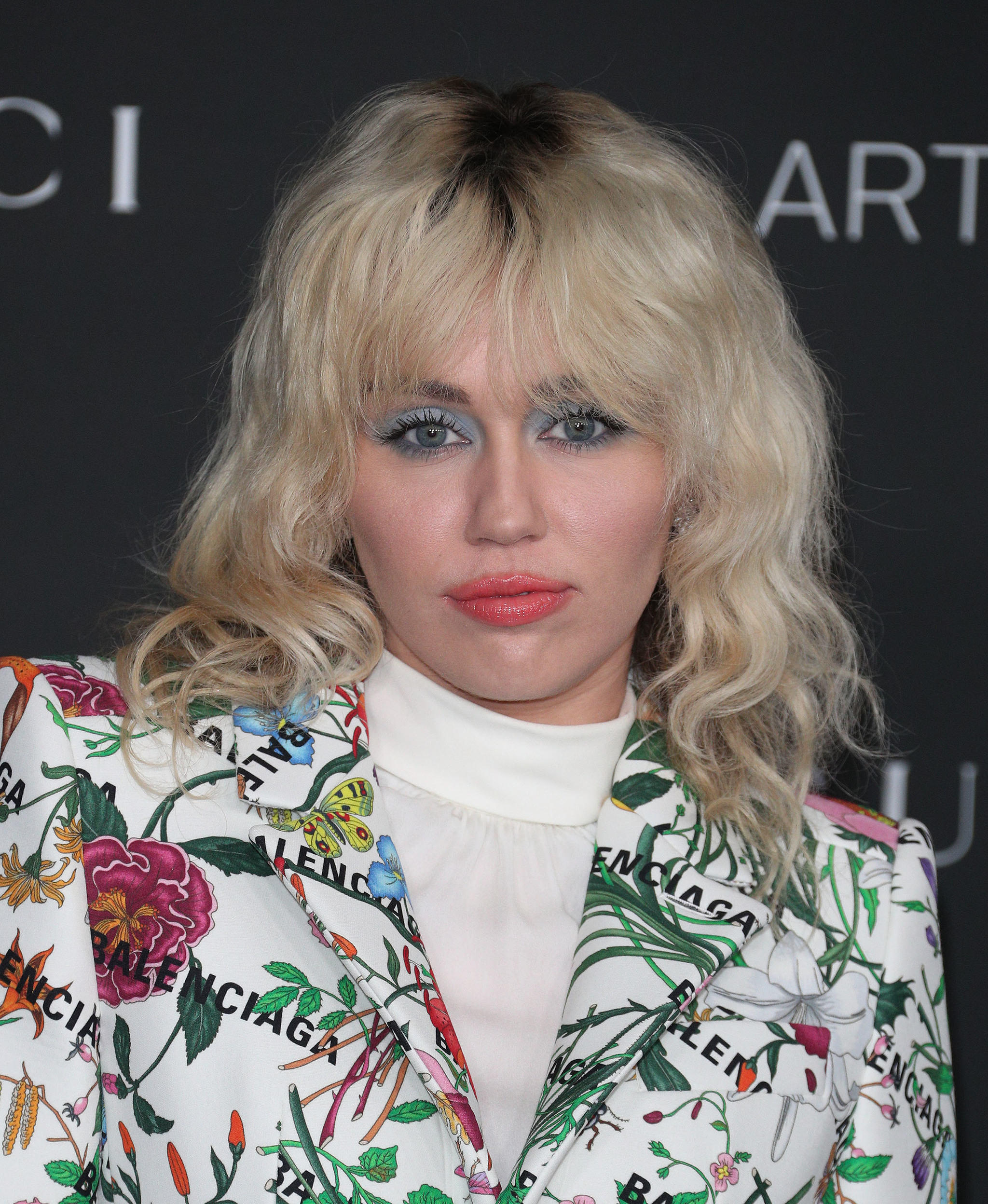 Miley Cyrus también elige este corte de pelo en su versión más rockera: rizado y en tono rubio platino con una marcada raíz.