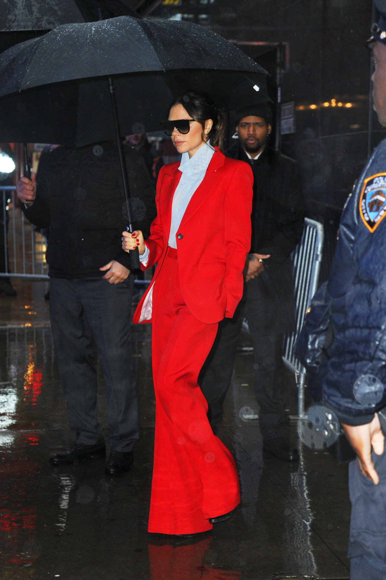 Victoria Beckham con traje de pantalon y americana en rojo