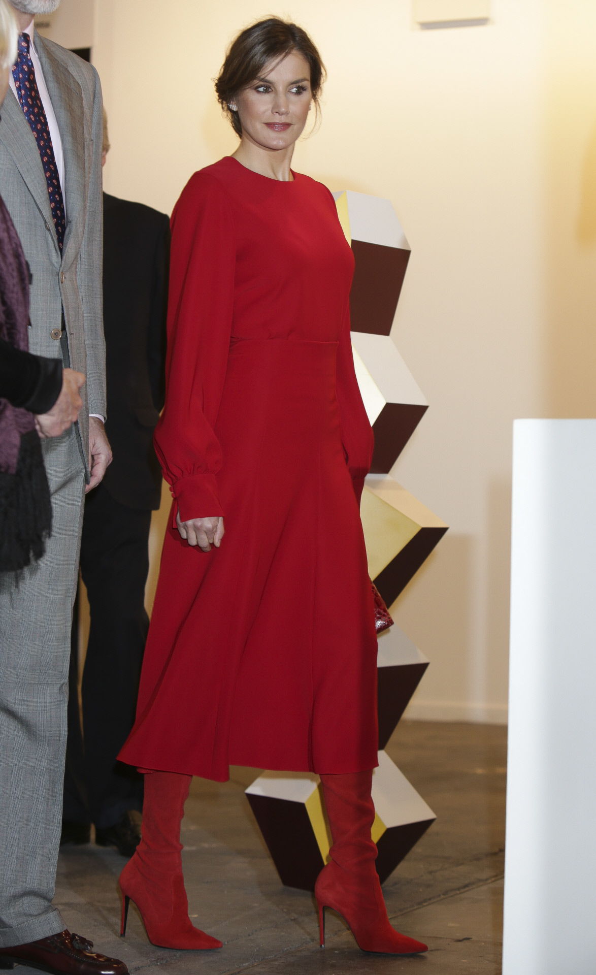 Look de la reina Letizia con vestido rojo y botas a juego.