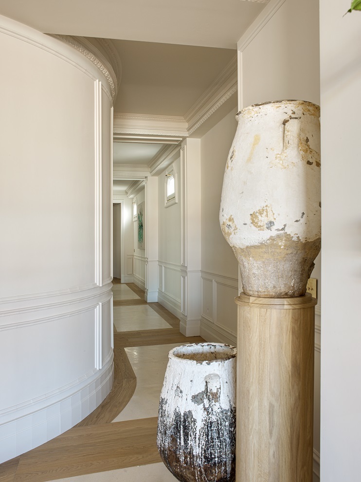 El pasillo, donde se aprovechó la curva de la arquitectura original, con peana de madera, realizada en el estudio con vasijas de Bingutti, la marca de muebles de María Santos.