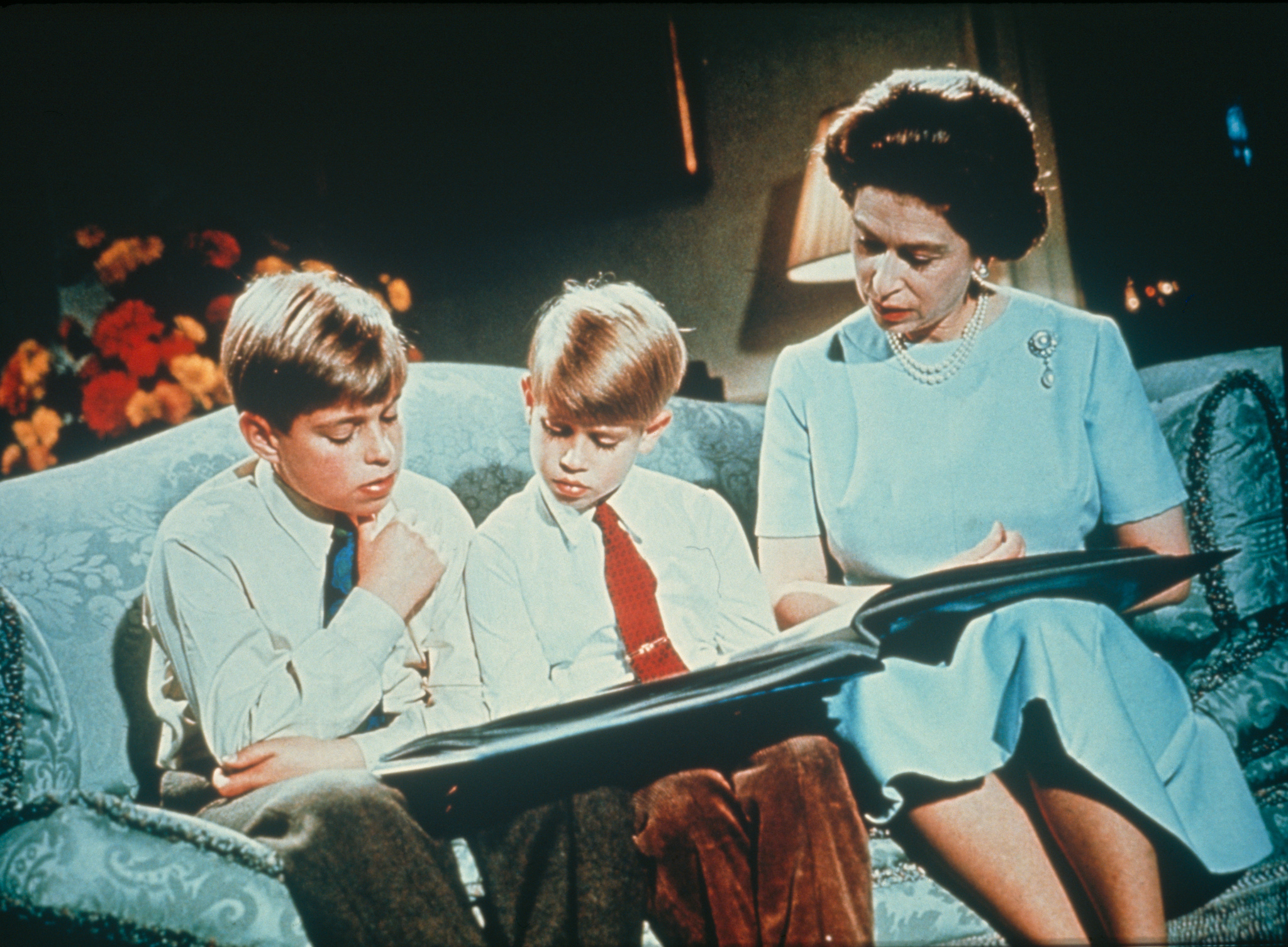 Isabel II lee un libro a sus hijos.