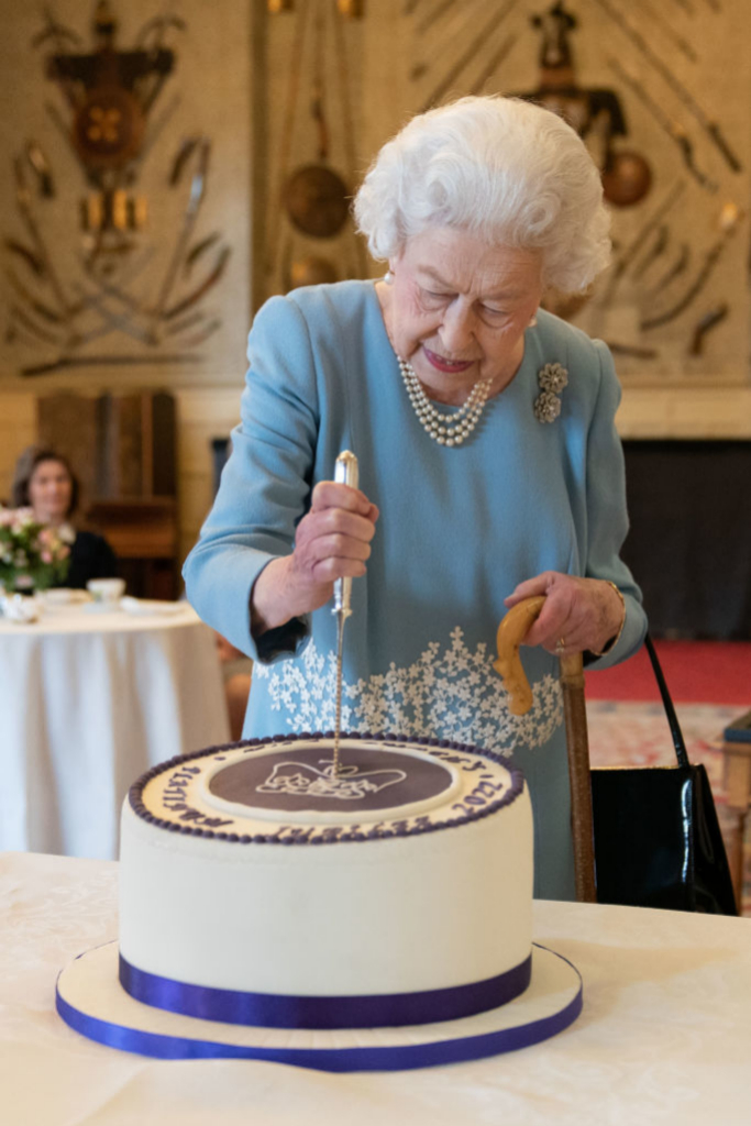La reina corta la tarta de su cumpleaños