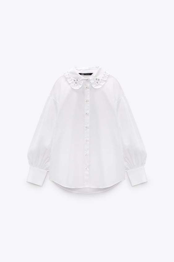 Camisa con cuello en detalle joya. Zara (25, 95 euros).