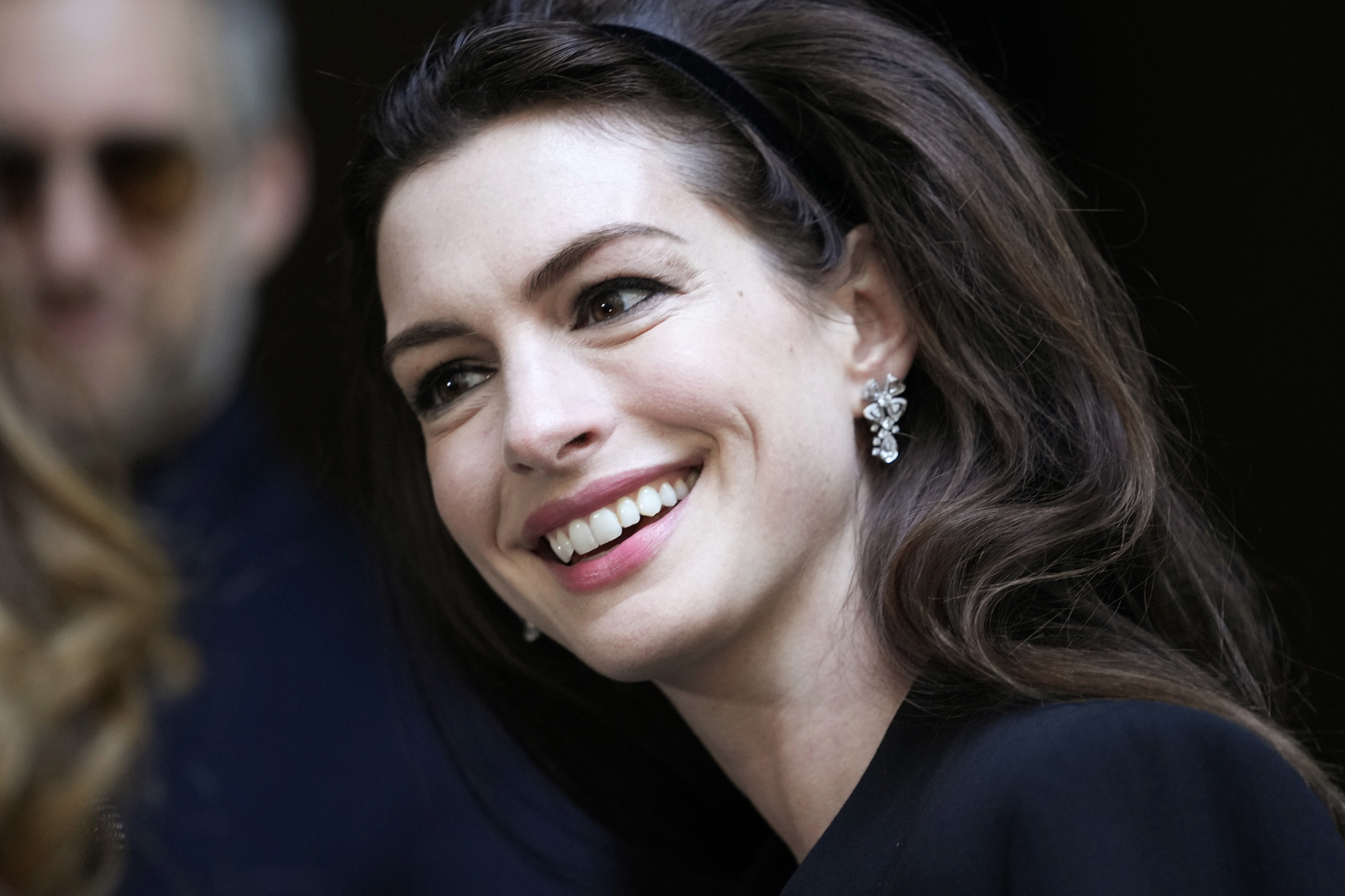 Anne Hathaway acompañó su melena con volumen de un maquillaje con altas dosis de lápiz de ojos negro y máscara de pestañas.