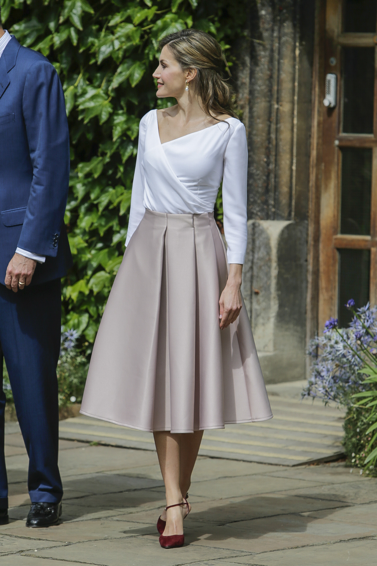 El look de la reina Letizia en Londres con top blanco y falda evasé.