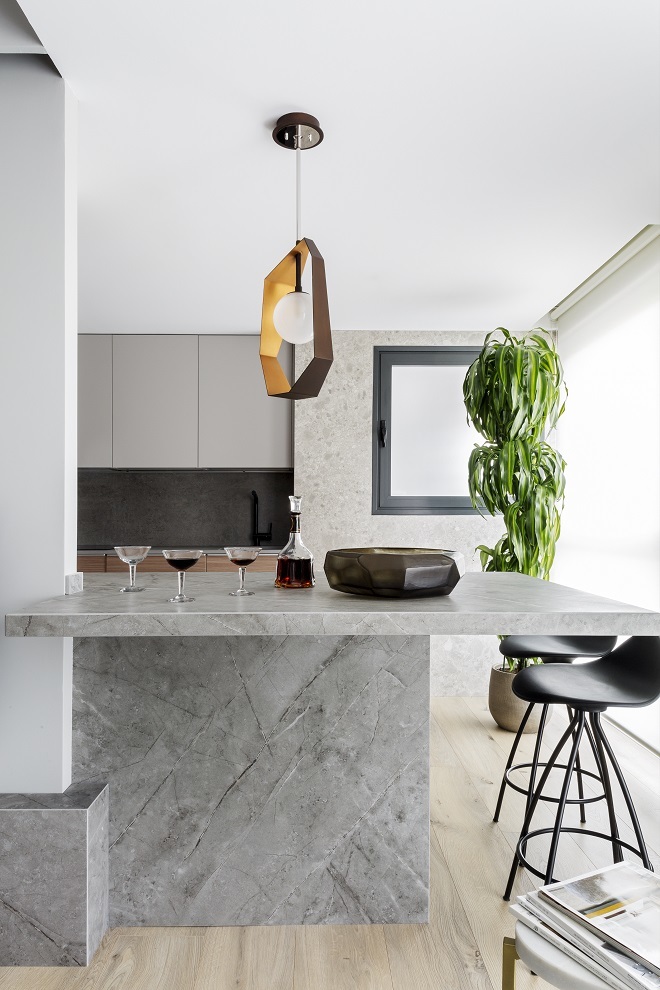 La cocina es un diseño de Mikel Irastorza, con isla de piedra de Dekton, taburetes de Stua y lámpara de techo de HVLG (Hudson Valley Lighting Group)