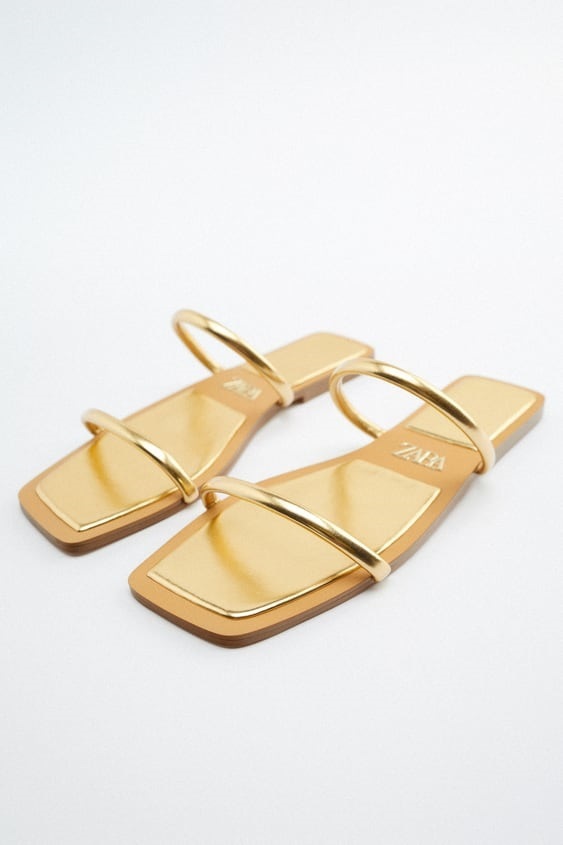Sandalias planas doradas de Zara.