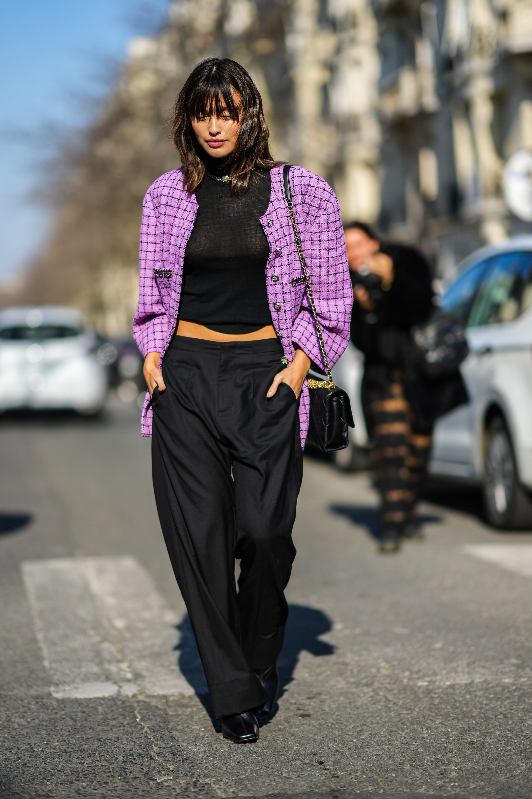 Una de las asistentes al desfile otoño-invierno 2022/2023 de Chanel, con pantalones anchos y chaqueta de tweed.