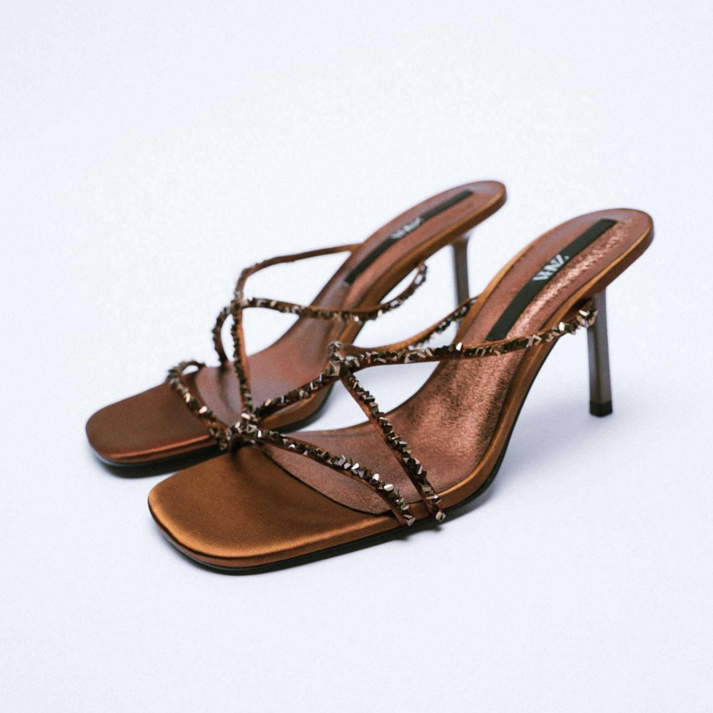 Zapato tipo sandalia de tacón de piel con tiras de brillos. Acabada en punta cuadrada. Zara (49,95 euros).