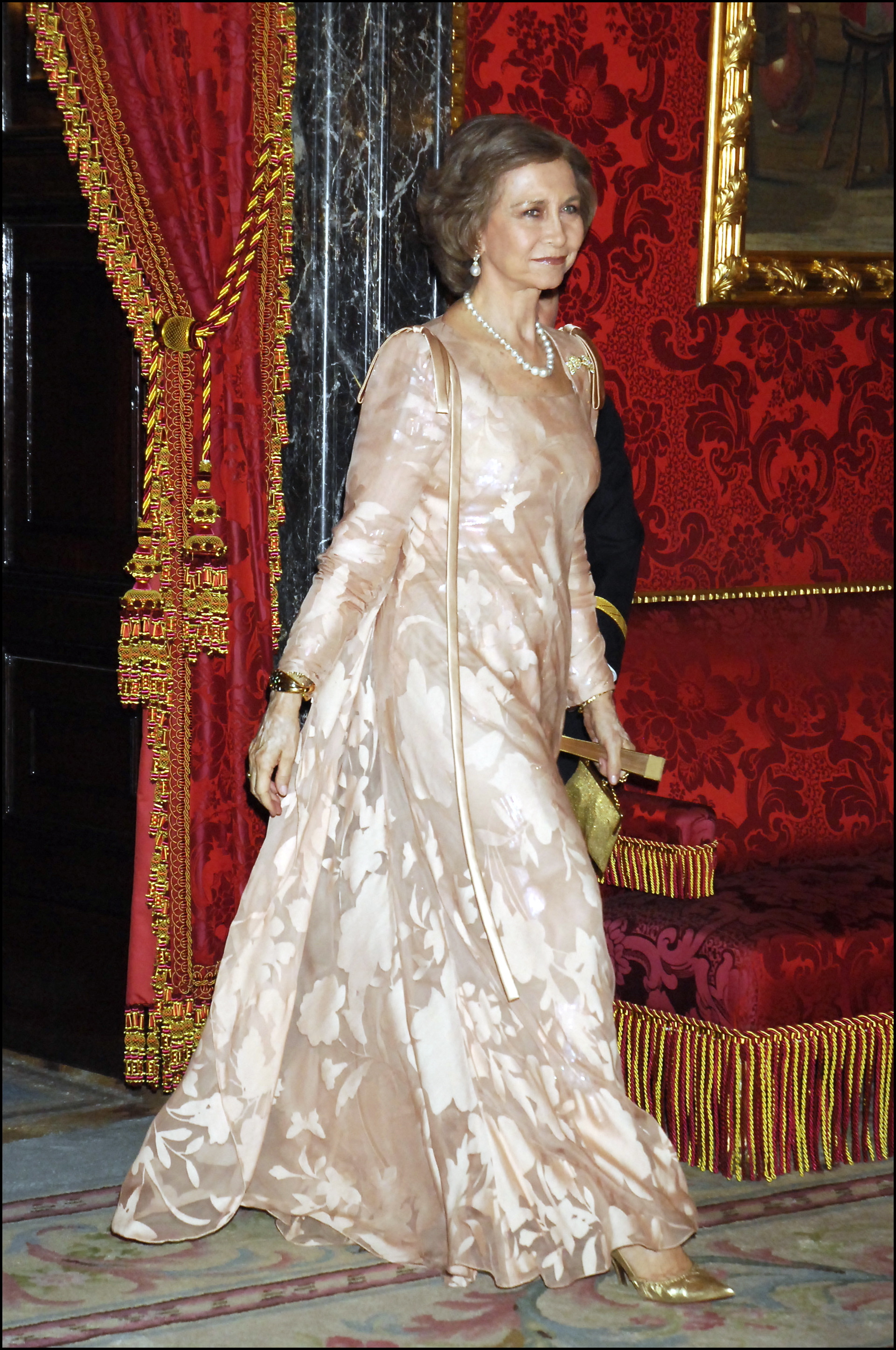 La reina Sofía con vestido largo y zapatos dorados.