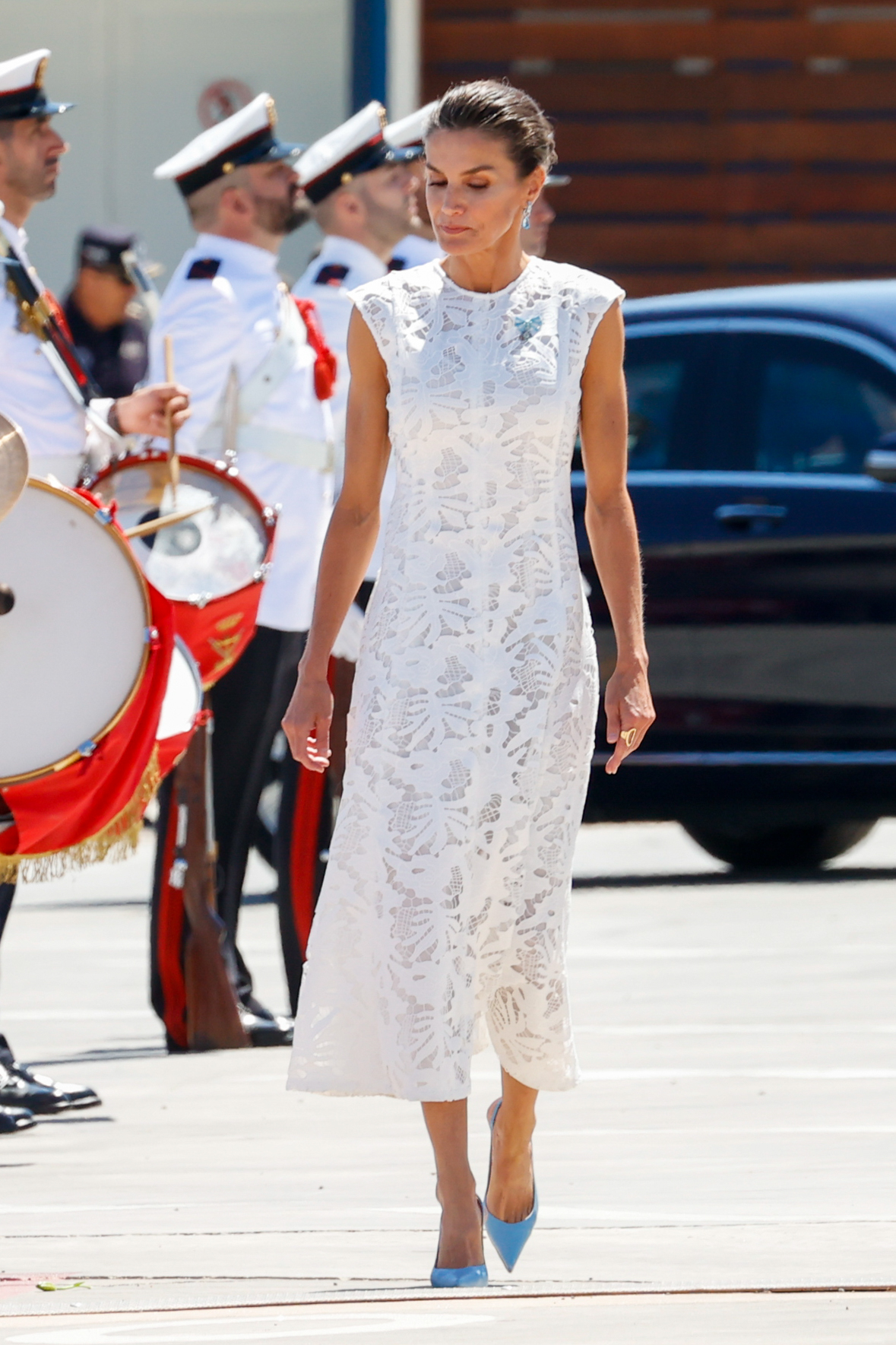 La reina escogió un vestido blanco de corte midi sin mangas.