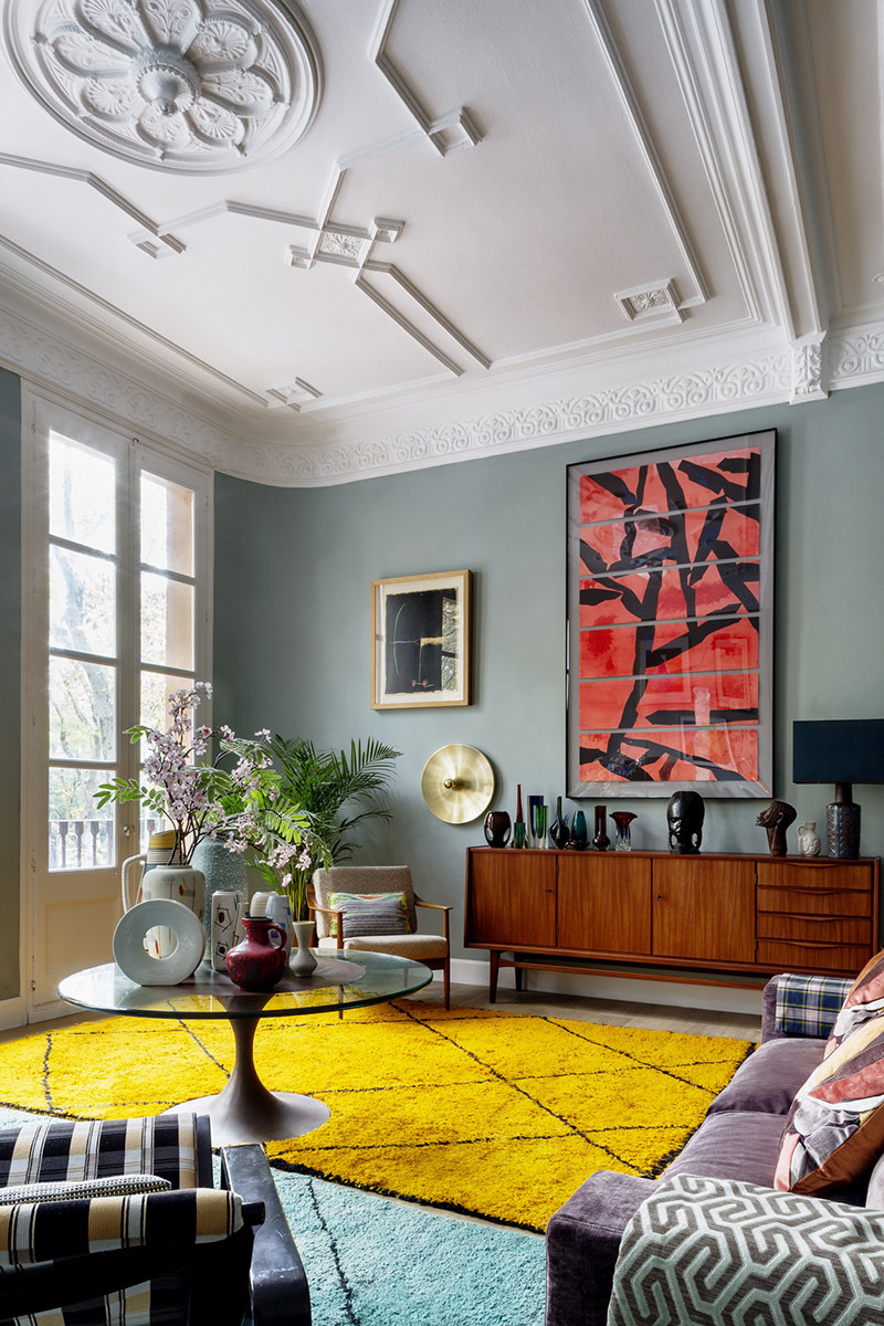 En el salón, al fondo, cuadro del pintor chino Wang Hualqing;  alfombras berebes compradas en Marrakech;  aparador danés;  mesa de centro y butaca compradas en Alemania; el disco dorado en la pared es un aplique danés