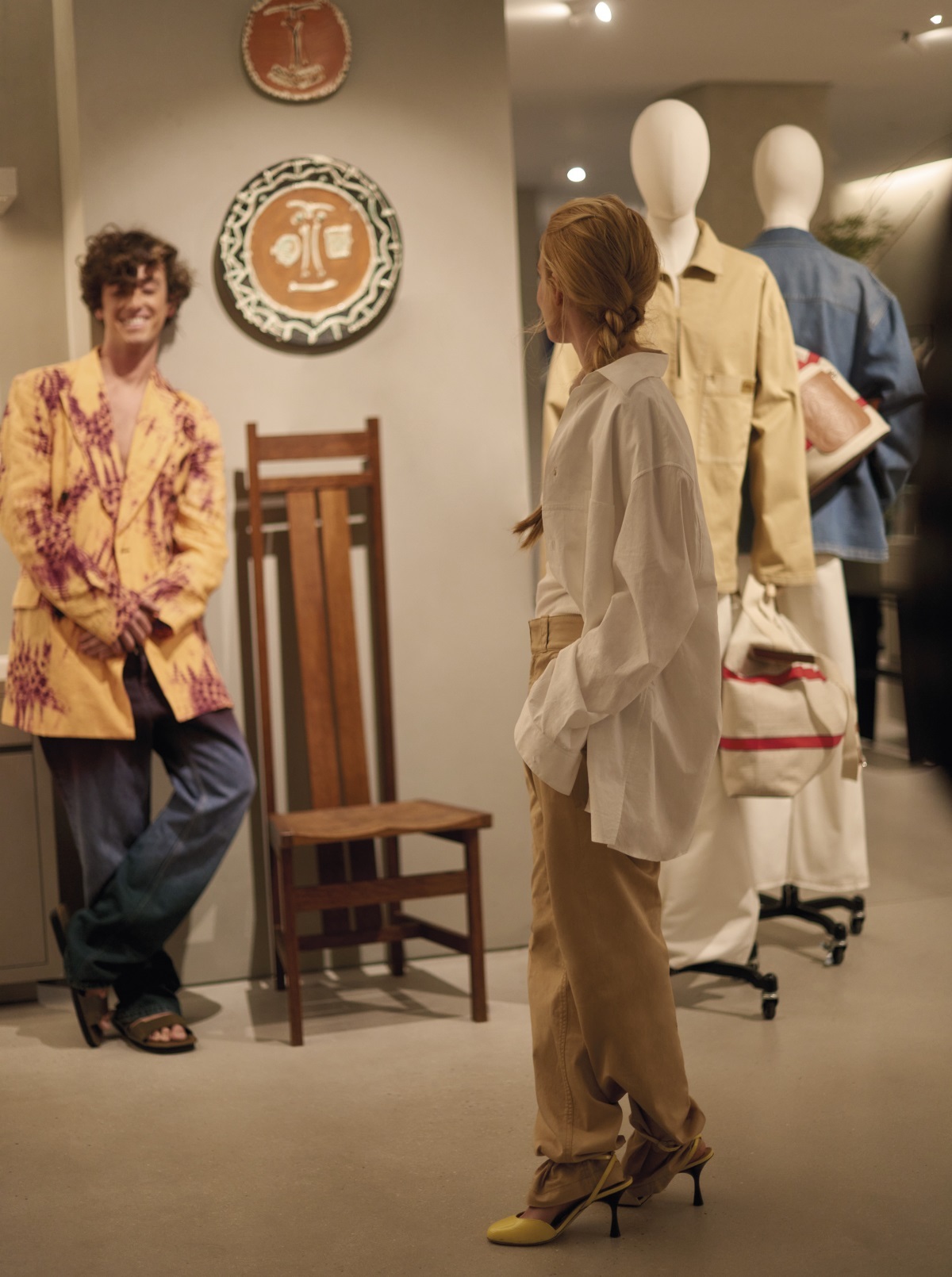 Álvaro y Blanca con total looks de la colección Paula's Ibiza, de Loewe posan en la nueva boutique de la marca frente a cerámicas de Pablo Picasso.