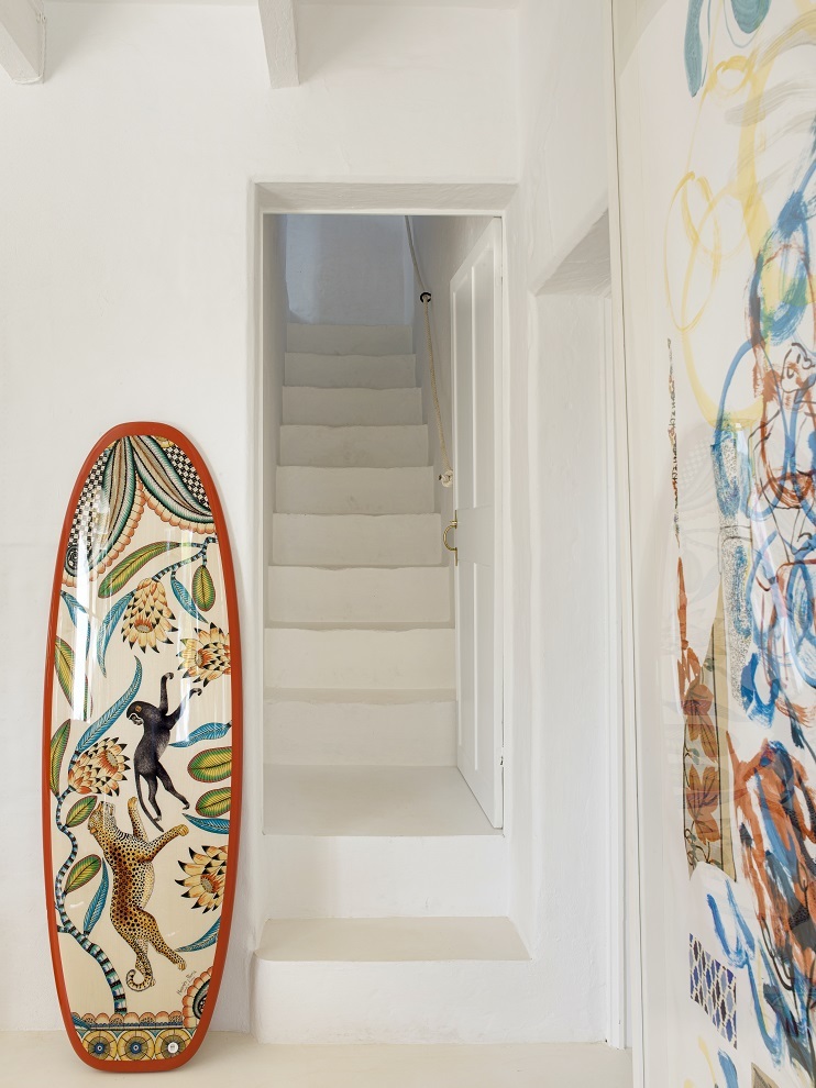 Al pie de las escaleras, tabla de surf de Hermès que Elizabeth regaló a su marido por su cincuenta cumpleaños