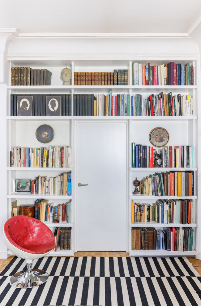 En la bibilioteca, a la entrada de la casa, silla huevo de Arne Jacobsen, uno de los hallazgos de la interiorista en el mercadillo inglés de Sunbury, en Surrey (Inglaterra). La alfombra de rayas es de Ikea.