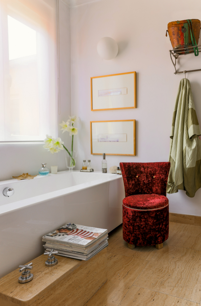 El cuarto de baño, con descalzadora de terciopelo rojo