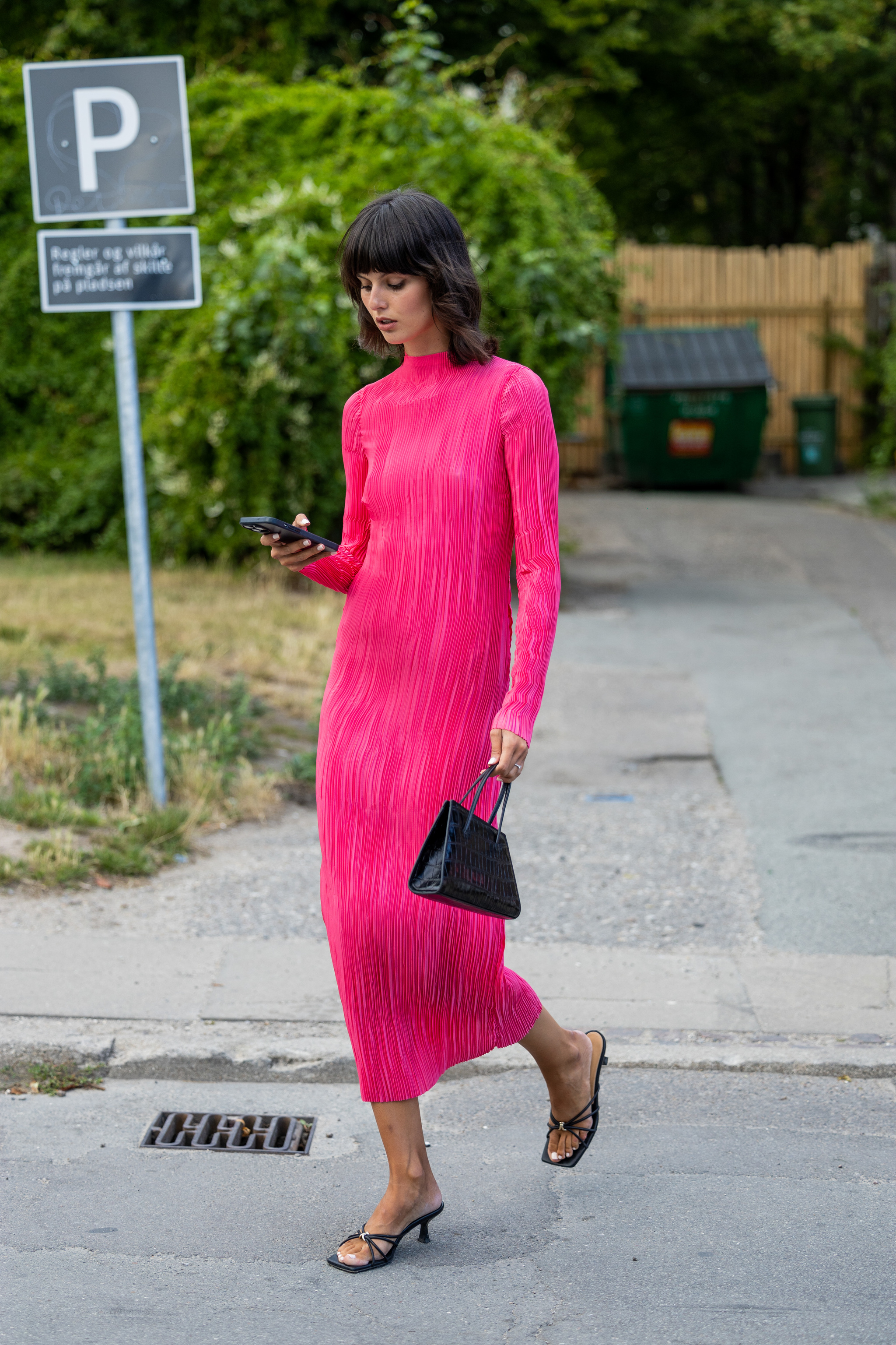Look de street style con vestido fucsia, una de las prendas clave del otoño 2022.