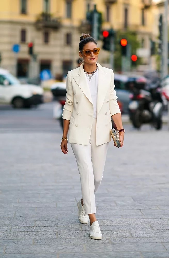 Olivia Palermo con traje de chaqueta blanco y zapatillas.