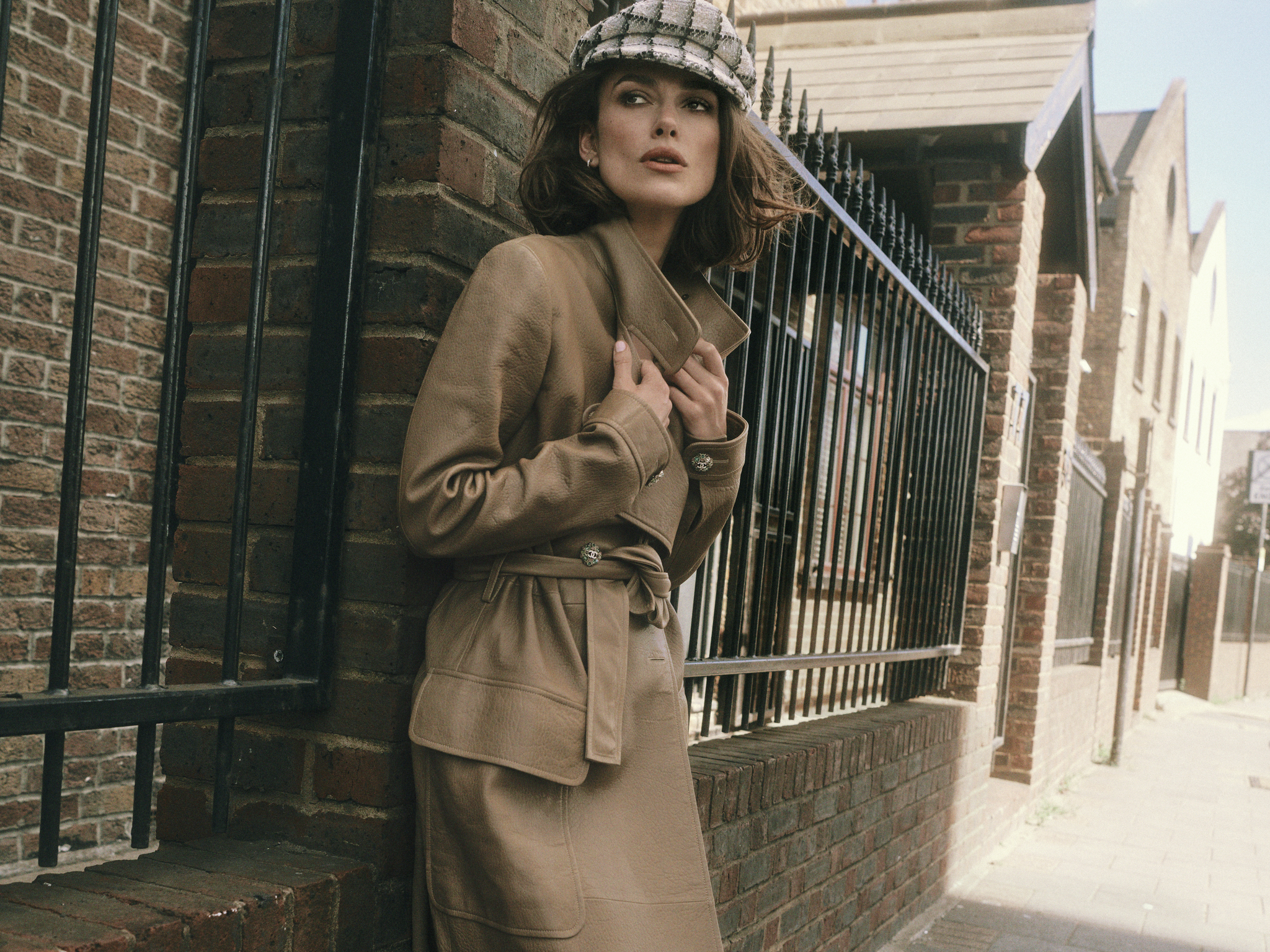 Keira Knightley con gabardina de piel de cordero beige, boina de tweed, y pendientes de aro. Todo, Chanel.