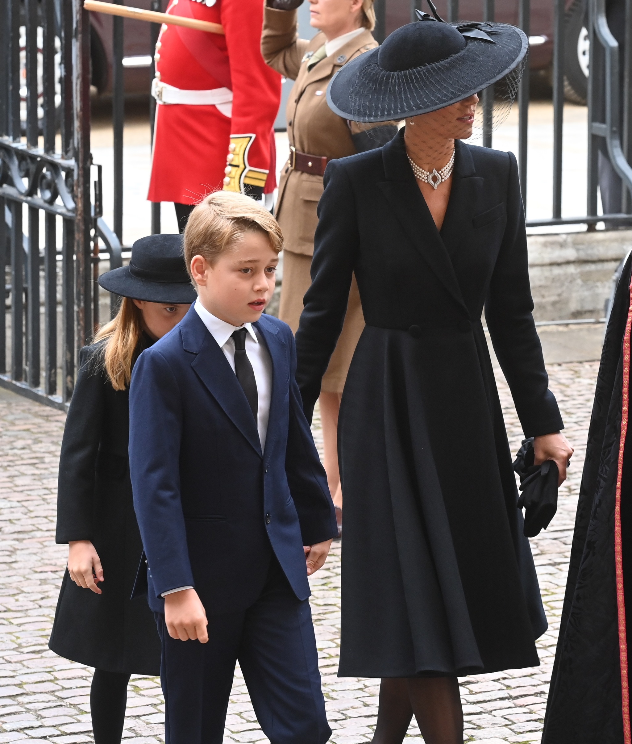 Kate Middleton con un abrigo-vestido negro con sus hijos Jorge y Carlota.