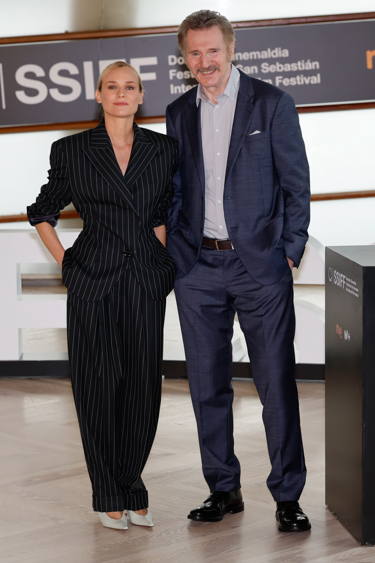 Diane Kruger y Liam Neeson esta mañana en el Festival de San Sebastián. La actriz con un impecable traje de chaqueta de raya diplomática y corte relajado. También en blanco y negro.