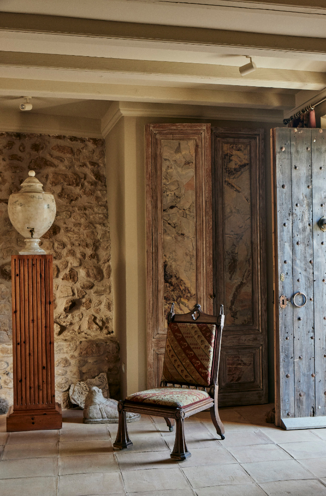 La entrada principal de la casa, con piedra original en las paredes y suelo de losas con barro artesanal. El aguamanil ha viajado por las distintas casas de Pascua y las puertas se realizaron con madera y mármol italiano de época.
