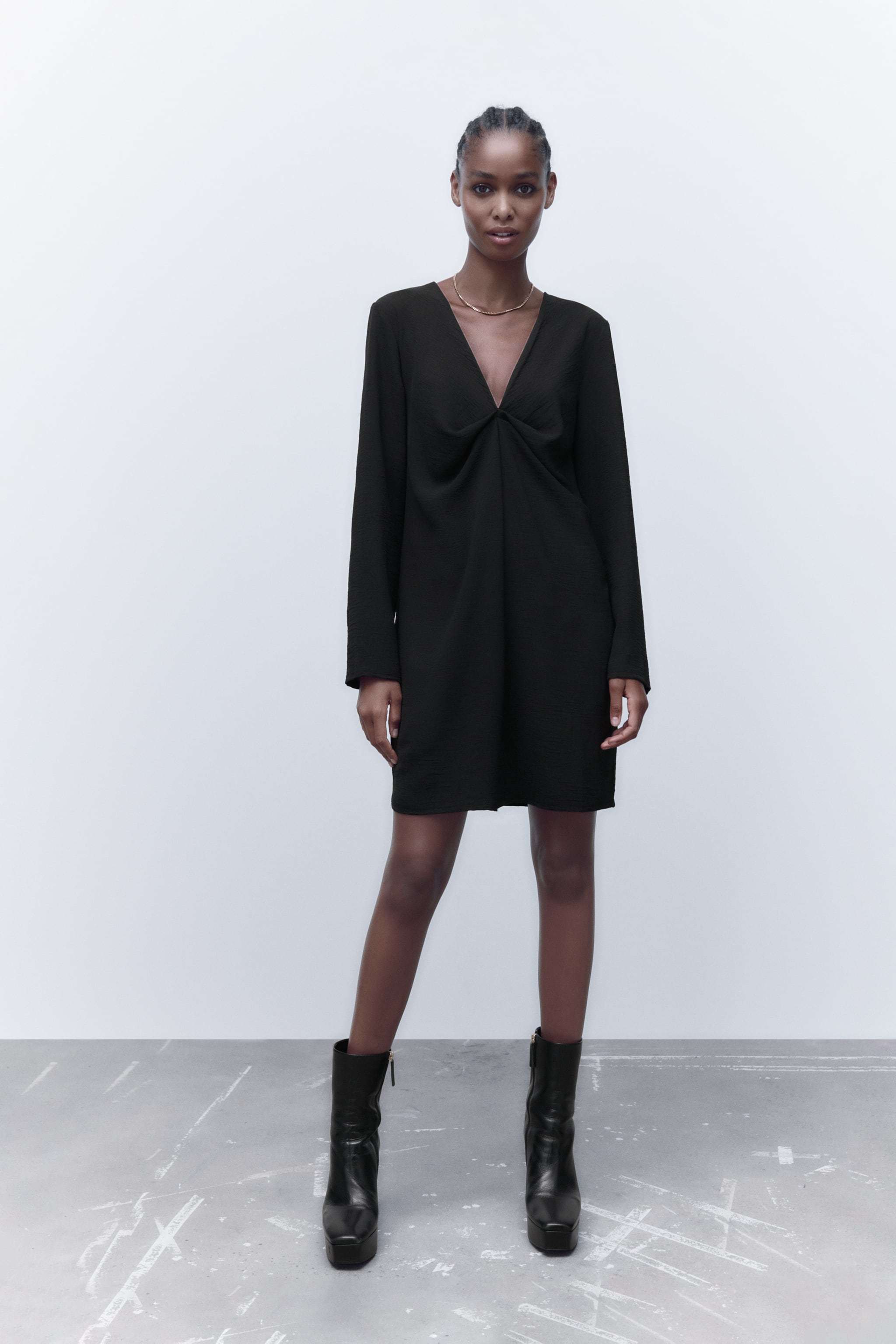 Vestido negro con cuello en uve, de Zara.