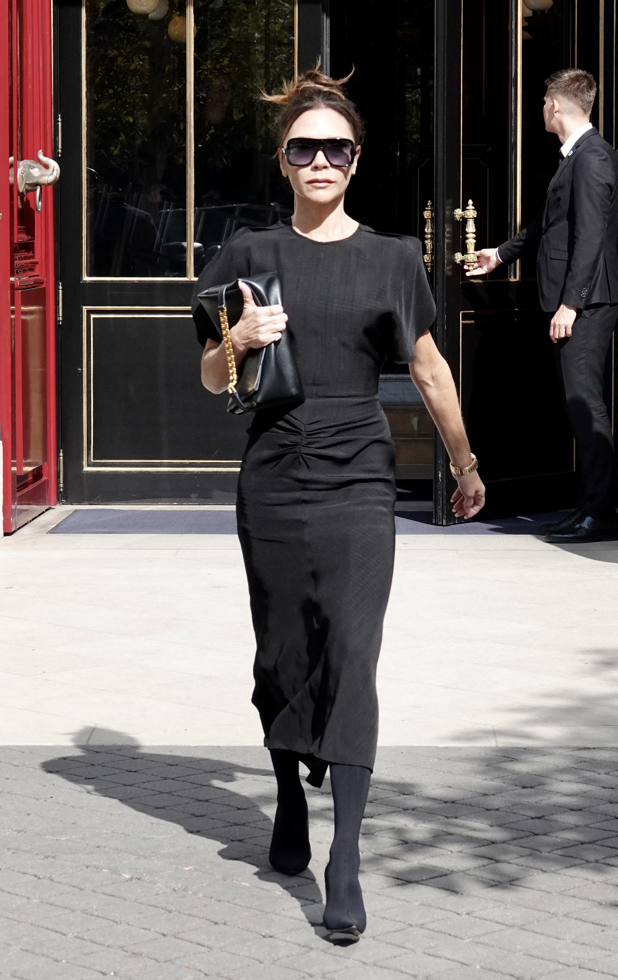 Victoria Beckham con falda negra midi.