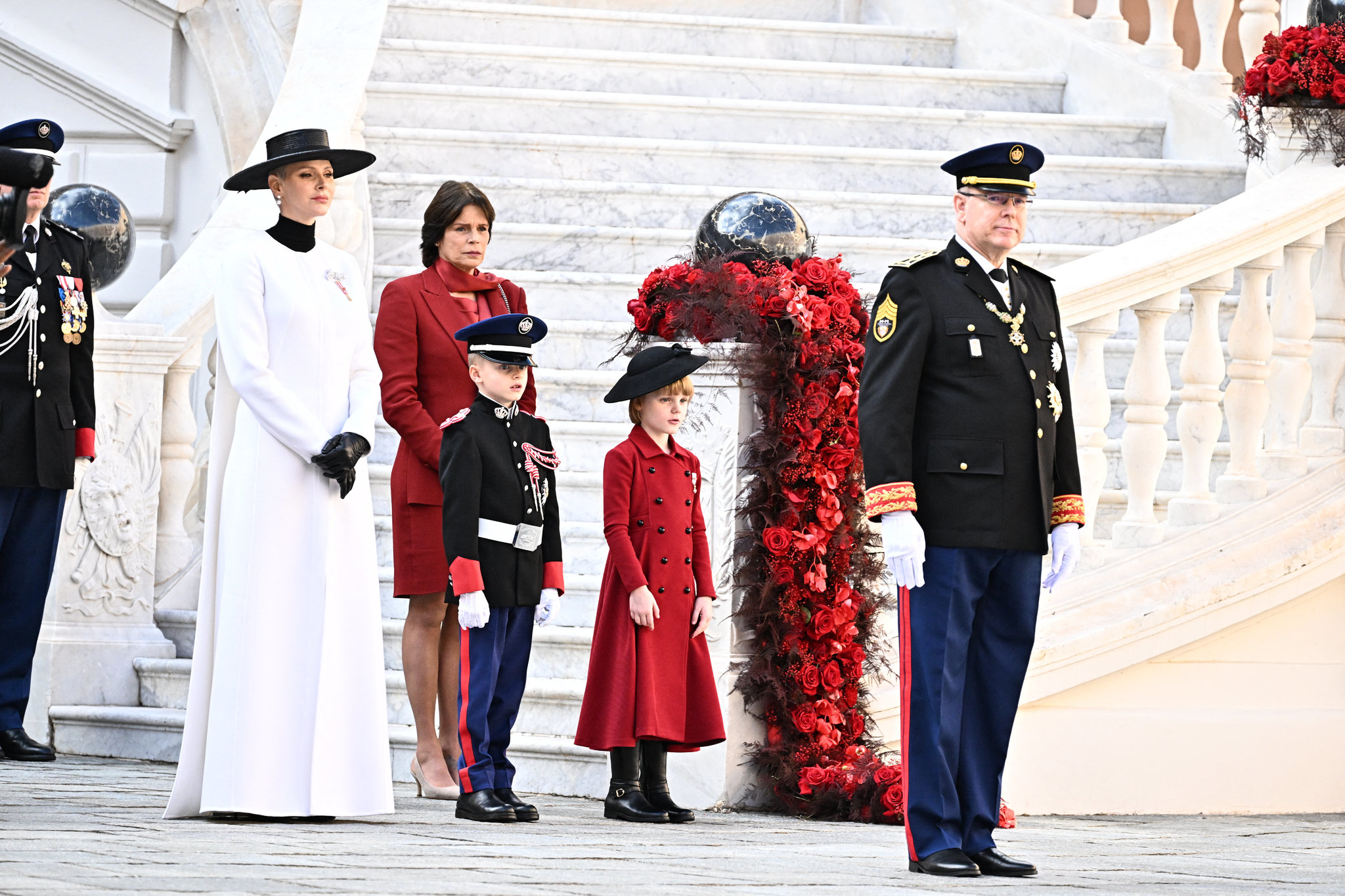 Daily News Alberto y Charlene de Mónaco con sus hijos y la princesa Estefanía con un sastre falda rojo.