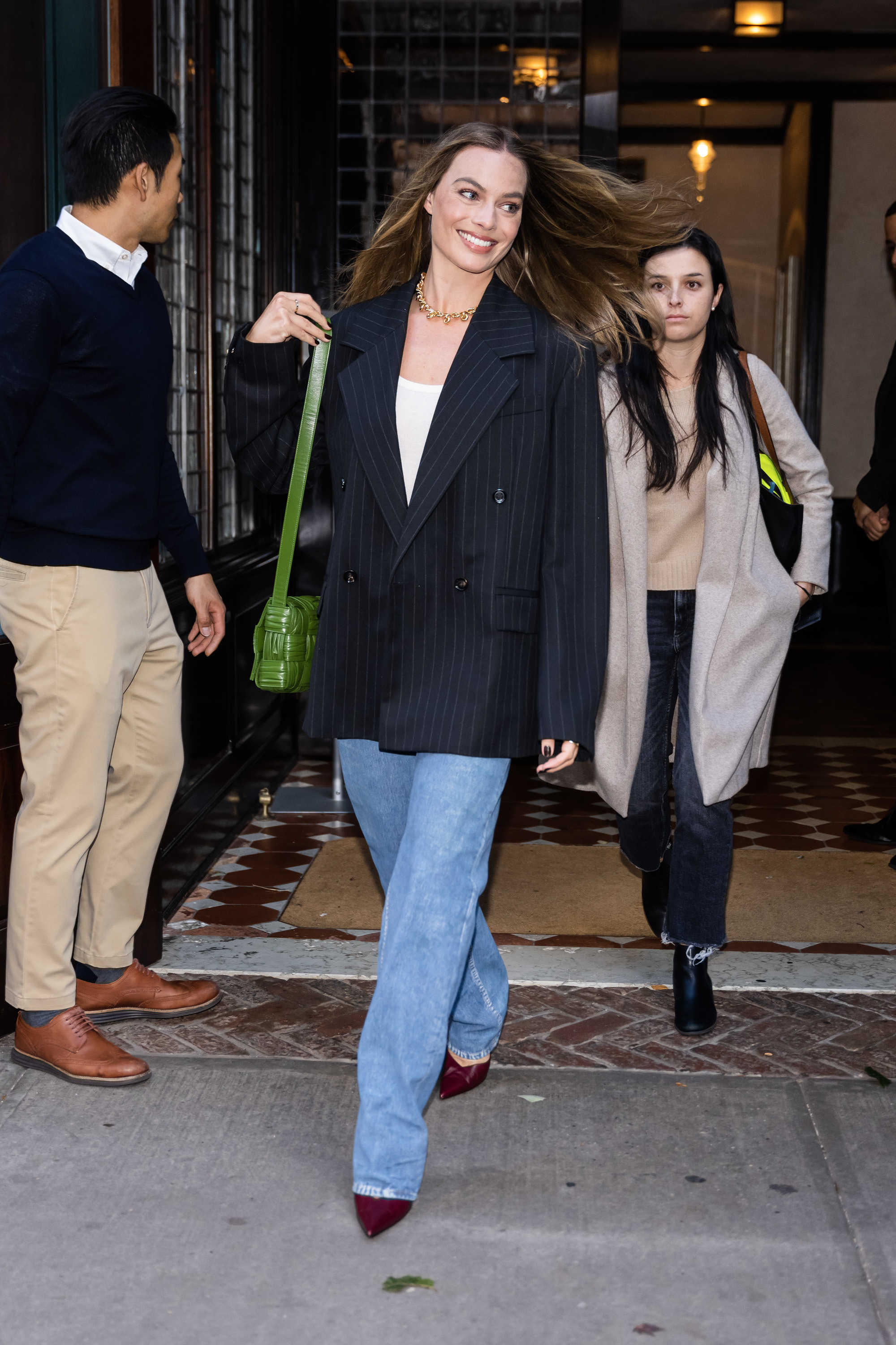 Margot Robbie con blazer de raya diplomática y jeans anchos.