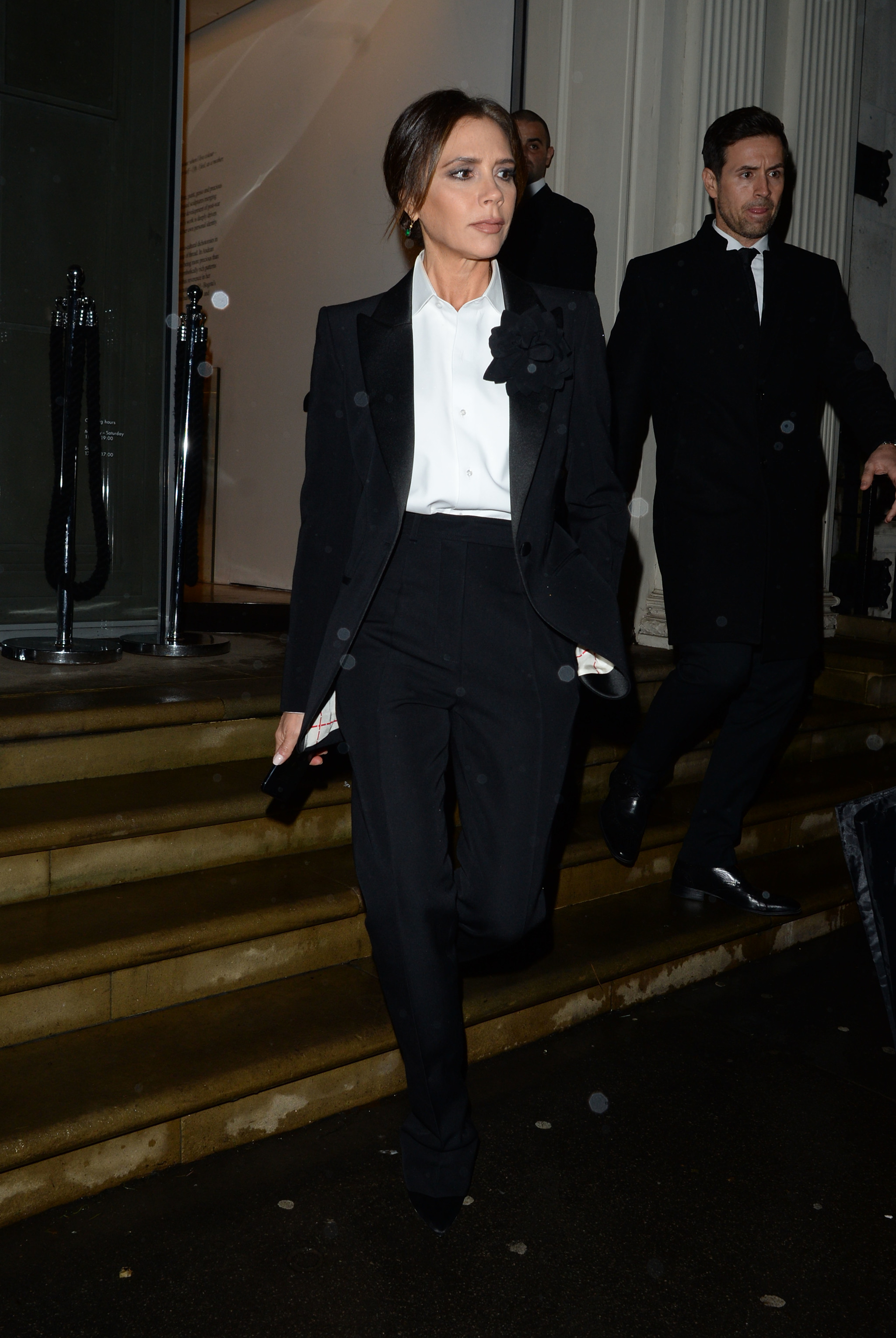 Victoria Beckham con un traje de chaqueta negro.
