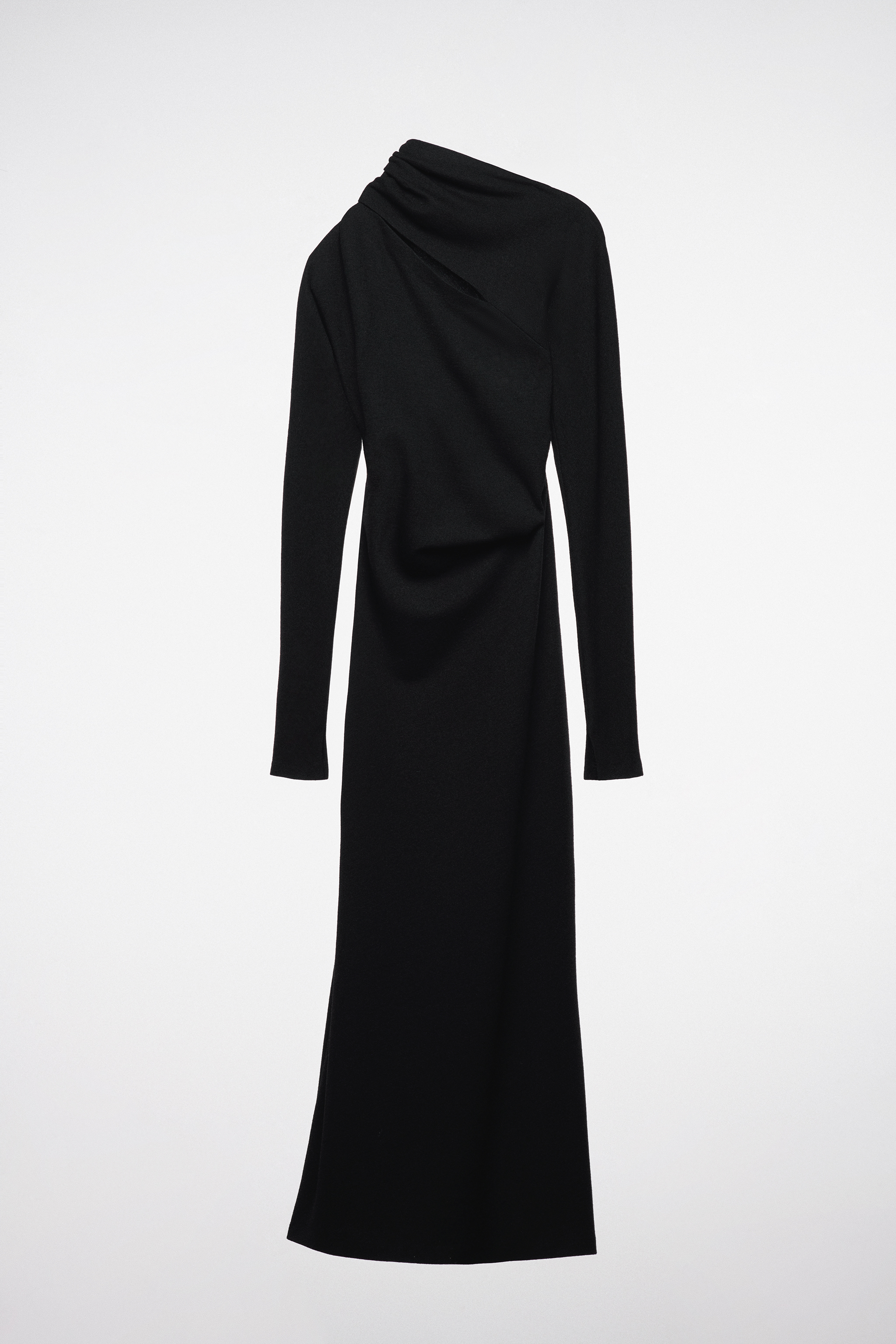 Un vestido negro que deja al descubierto un hombro de Zara.