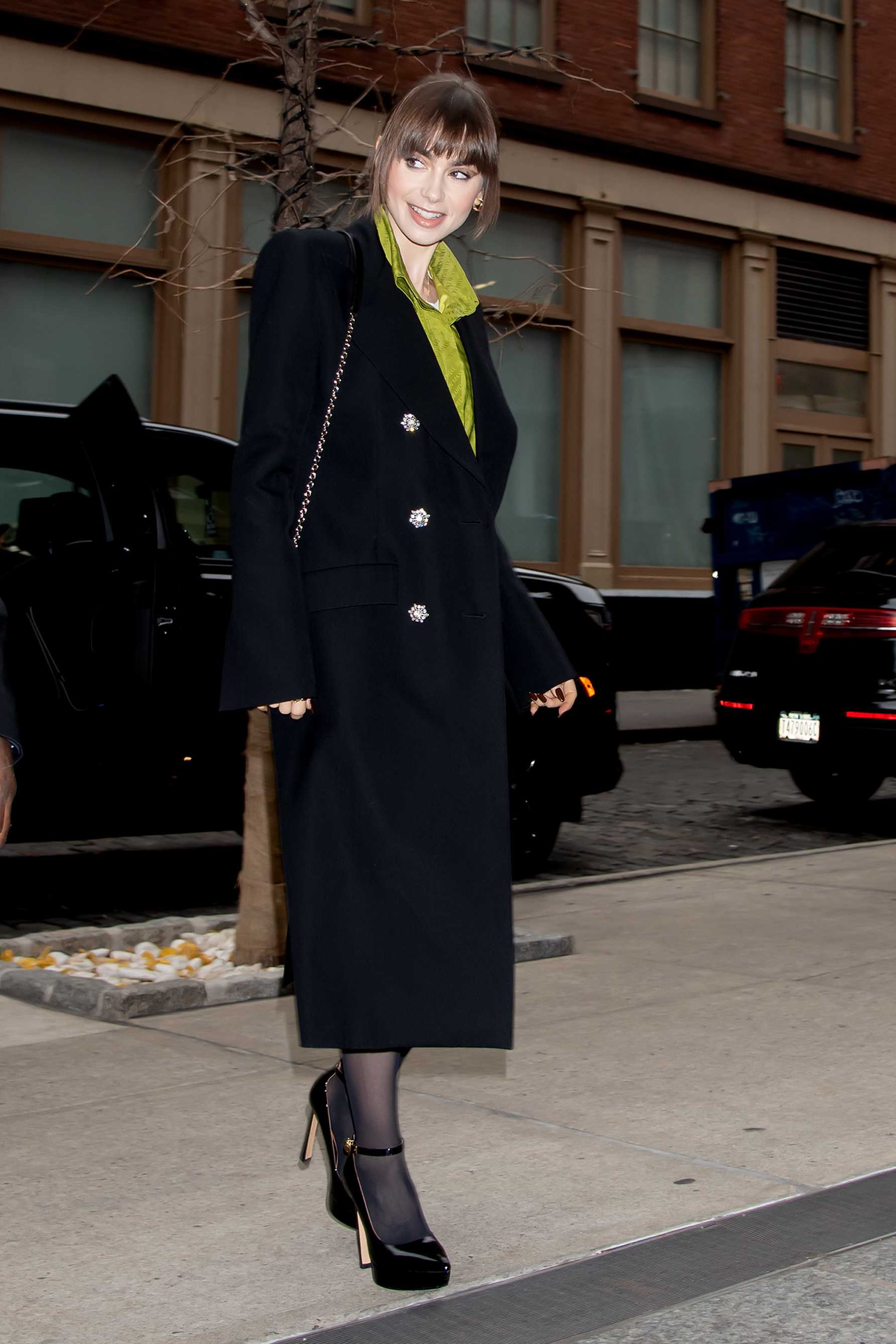 Lily Collins con abrigo de estilo navy.