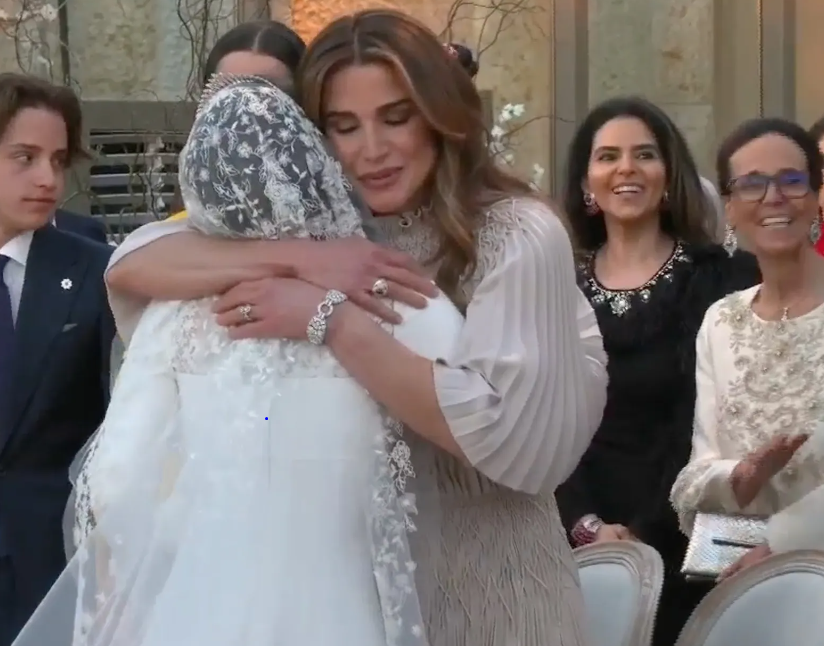 La reina Rania, que lució un vestido de Dior, abraza a su hija tras la ceremonia.
