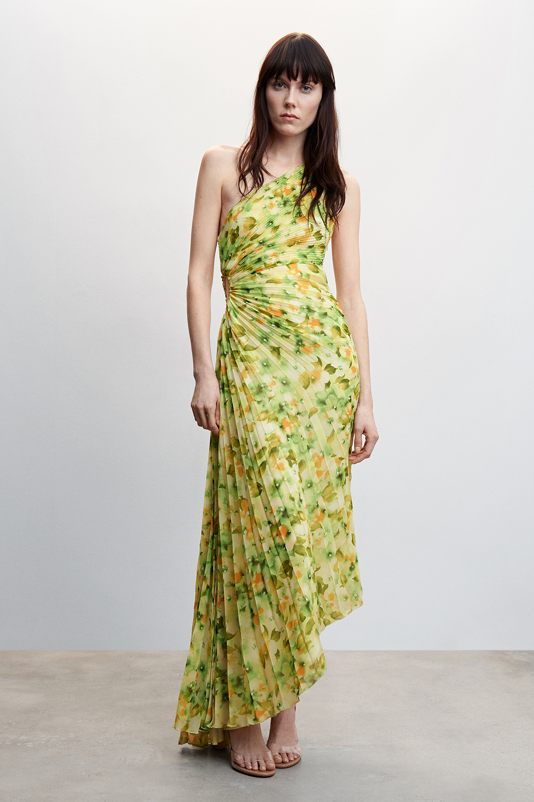 Vestido asimétrico con estampado floral y tejido plisado. Disponible para alquilar en Mango.