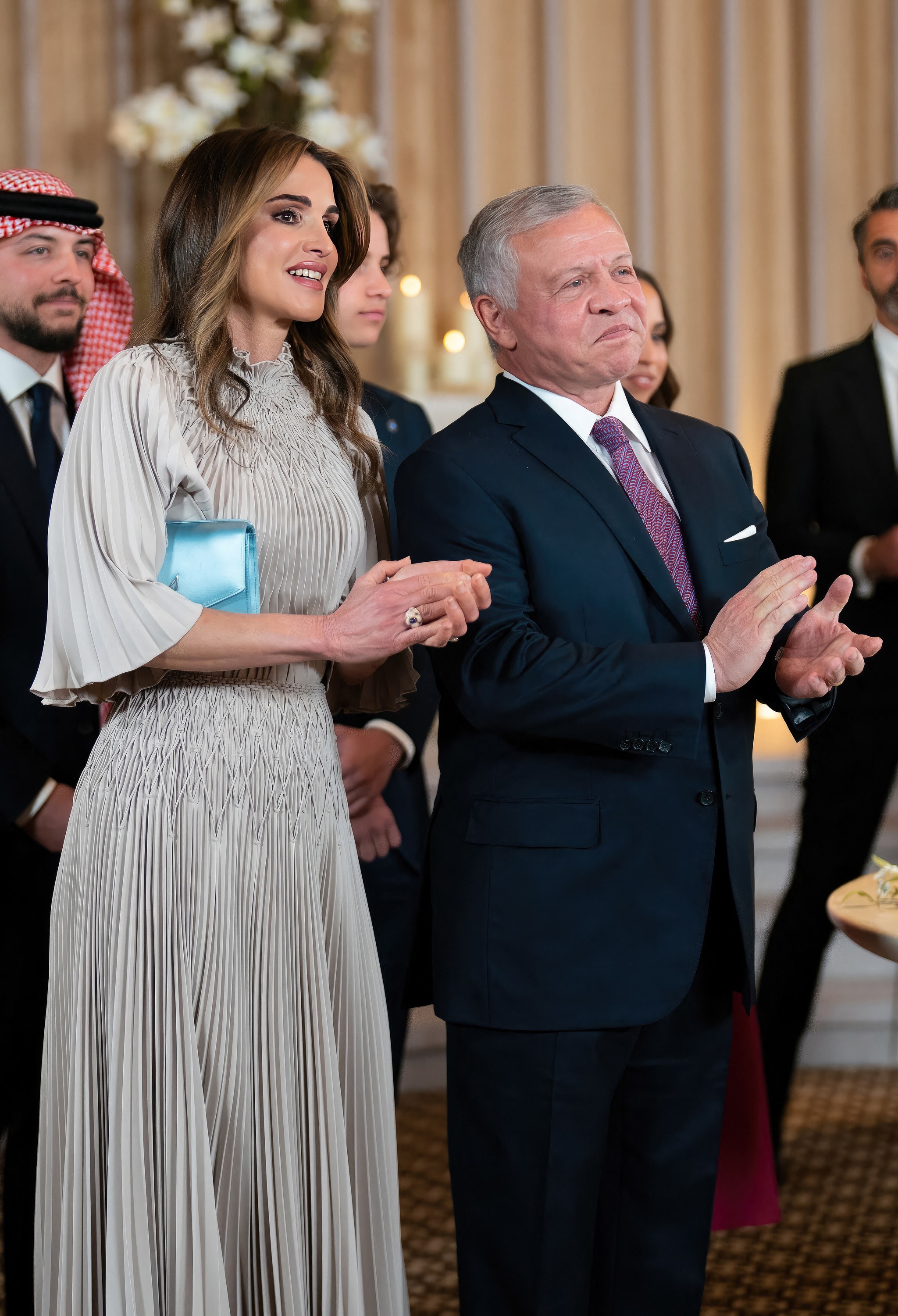 Rania de Jordania en la boda de su hija Iman con cartera azul.