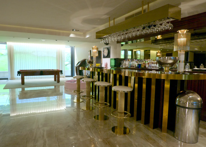 La bien surtida barra de bar de uno de los salones de la casa de alquiler de Cristiano Ronaldo y Georgina, en tonos dorados.
